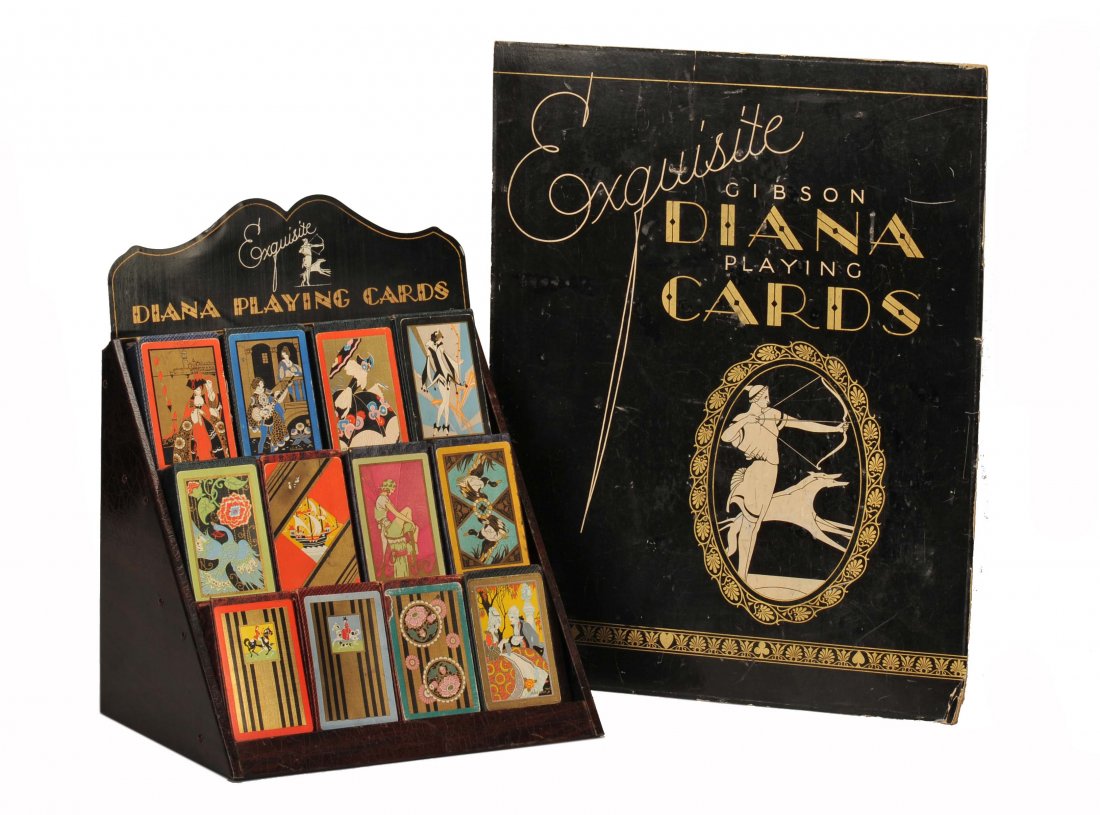 Three pieces of Art Deco playing card ephemera.: Three pieces of Art Deco playing card ephemera. Including a cardboard art deco display sign advertising “Diana Playing Cards,” ca. 1930. 18 x 14”; a tin display stand for 12 decks, ca. 1930, 14 