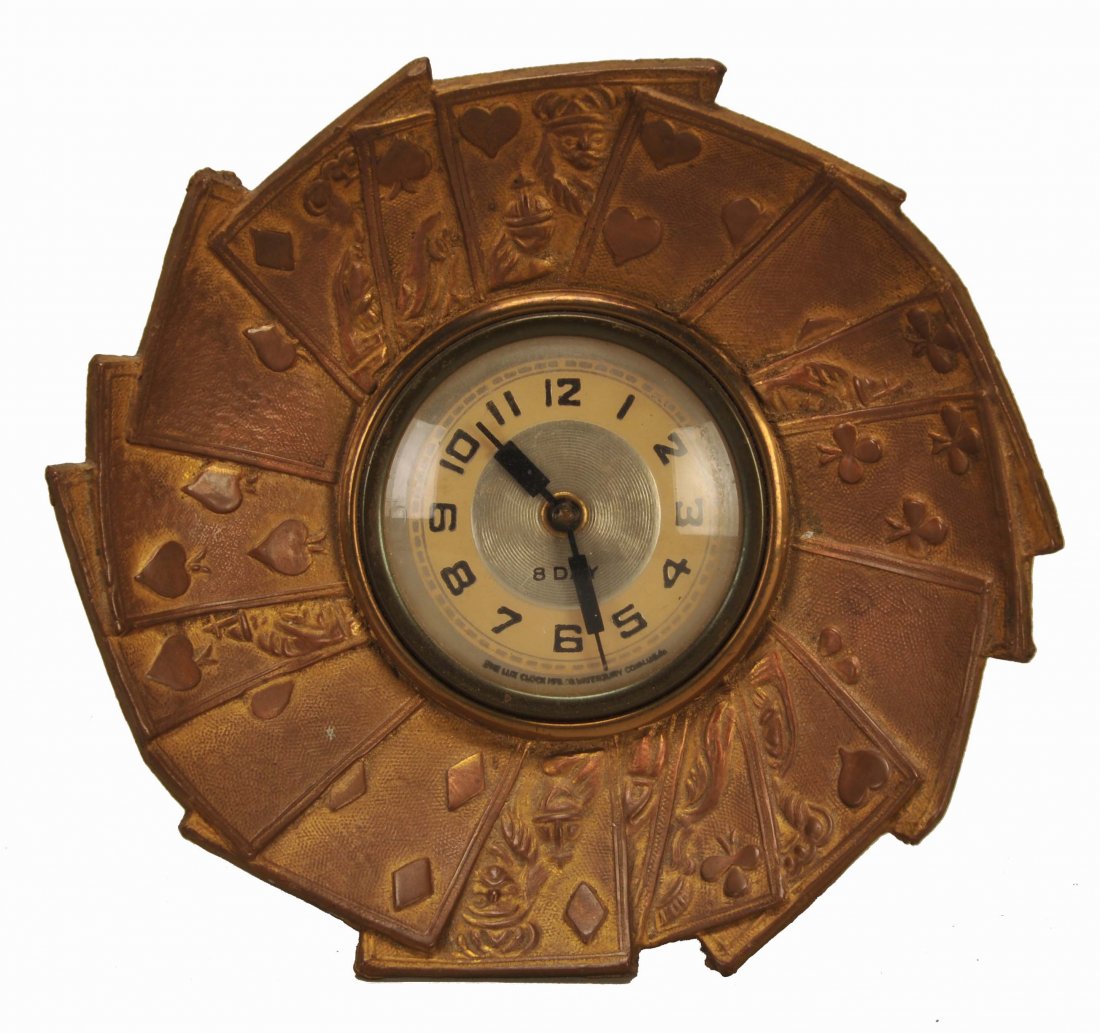 Eight Day Clock Set in a Circle of Embossed Brass: Eight Day Clock Set in a Circle of Embossed Brass Playing Cards. Lux Clock Mfg. Co., Waterbury, Connecticut, ca. 1900. With original stand on the back often broken off or missing. 5”.