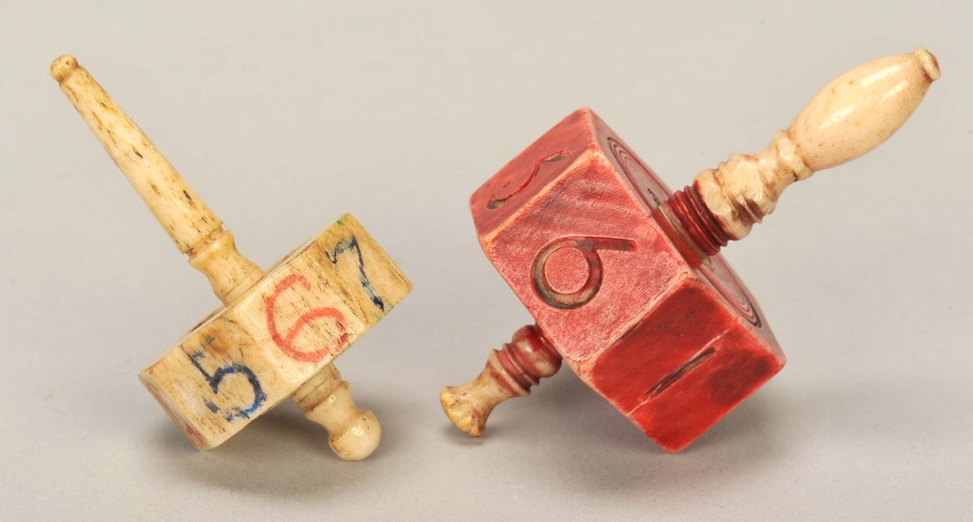 Pair of Bone Put & Take Tops. Ca. 1890. The handle on: Pair of Bone Put & Take Tops. Ca. 1890. The handle on the red top unscrews to release miniature dice, which are missing. VG.