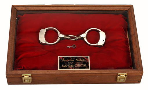 Houdini Regulation Bean Prison Handcuffs. w/provenance.: Houdini Bean Prison Handcuffs. Pair of regulation handcuffs owned by Houdini, and later his brother Hardeen. Patented Nov. 28, 1882. With key. Housed in a hardwood display case with engraved plaque