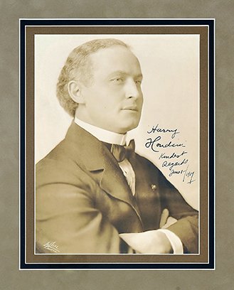 Portrait of Harry Houdini inscribed and signed. 1916.: Houdini, Harry. Portrait of Harry Houdini inscribed and signed. Seattle, LaPine photographer, ca. 1916. Striking half-length sepia-toned portrait of Houdini in formal attire, his arms crossed in front