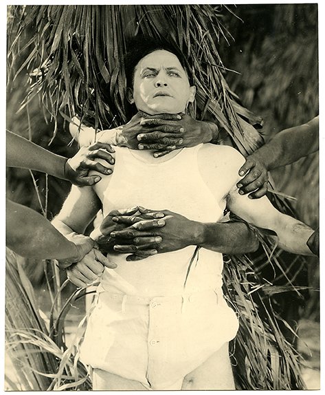 Houdini, Harry. Terror Island publicity photograph.: Houdini, Harry. Terror Island publicity photograph. Famous Players-Lasky Corp., 1920. The hands of savage “island natives” entrap Houdini. 7 ¼ x 9”. Photoplay Magazine library stamp on verso.