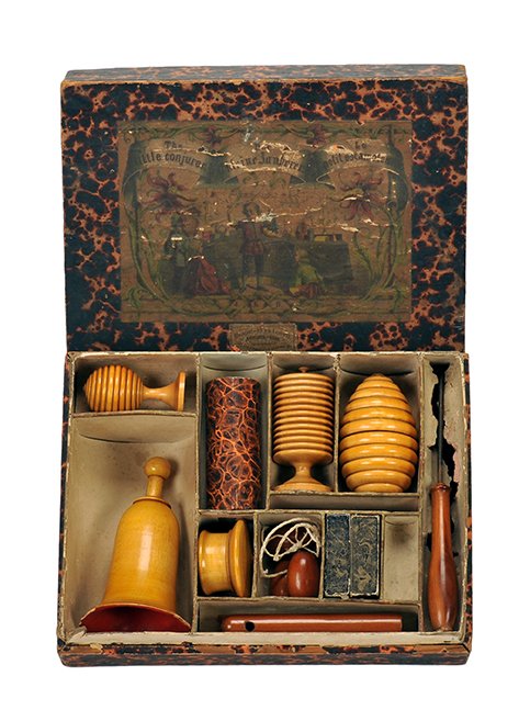 Little Conjurer Magic Set. Germany [?], ca. 1880.: Little Conjurer Magic Set. Germany [?], ca. 1880. Paper-covered wooden box with internal compartments and lithographed label. Tricks inside include turned wooden egg vase, ball vase, millet bell and c