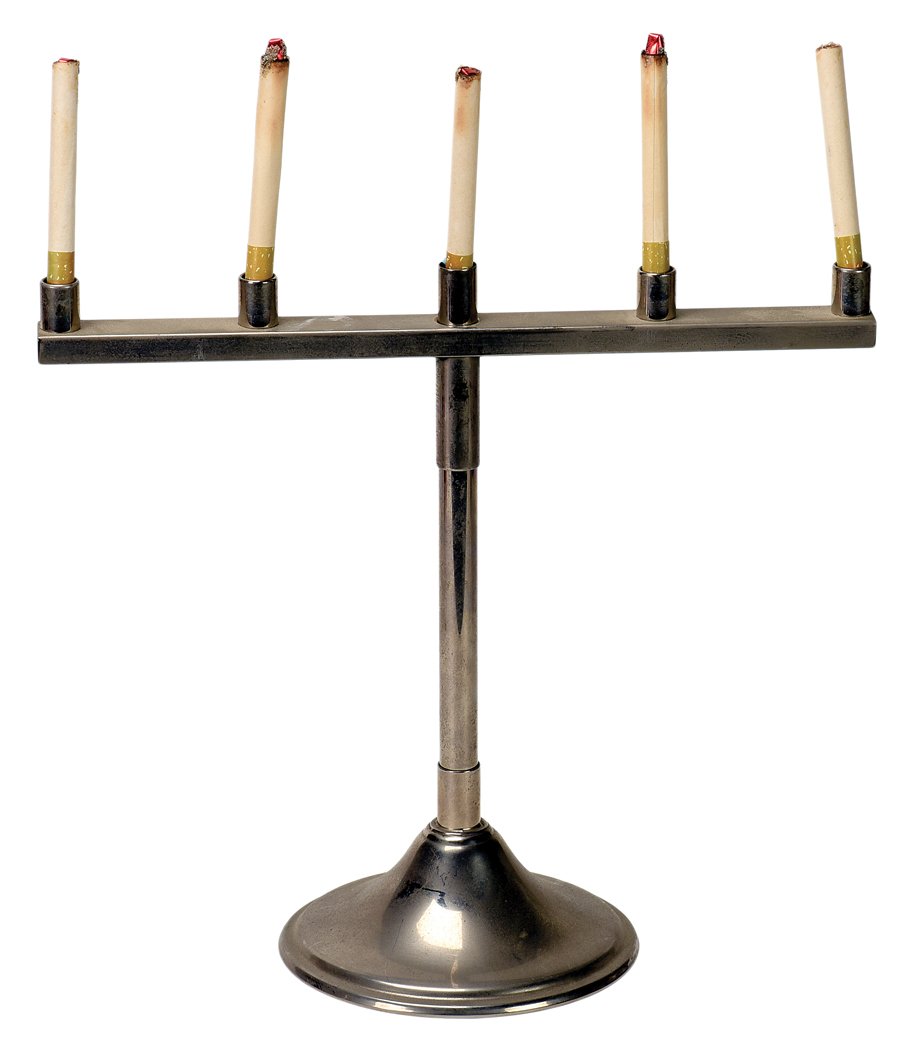 Cigarette/Candle Combination. New Haven, P & L.: Cigarette/Candle Combination. New Haven, Petrie & Lewis, ca. 1939. Short metal stand facilitates the production and vanish of lit cigarettes or birthday candles in the magician’s hands. Nickel plate