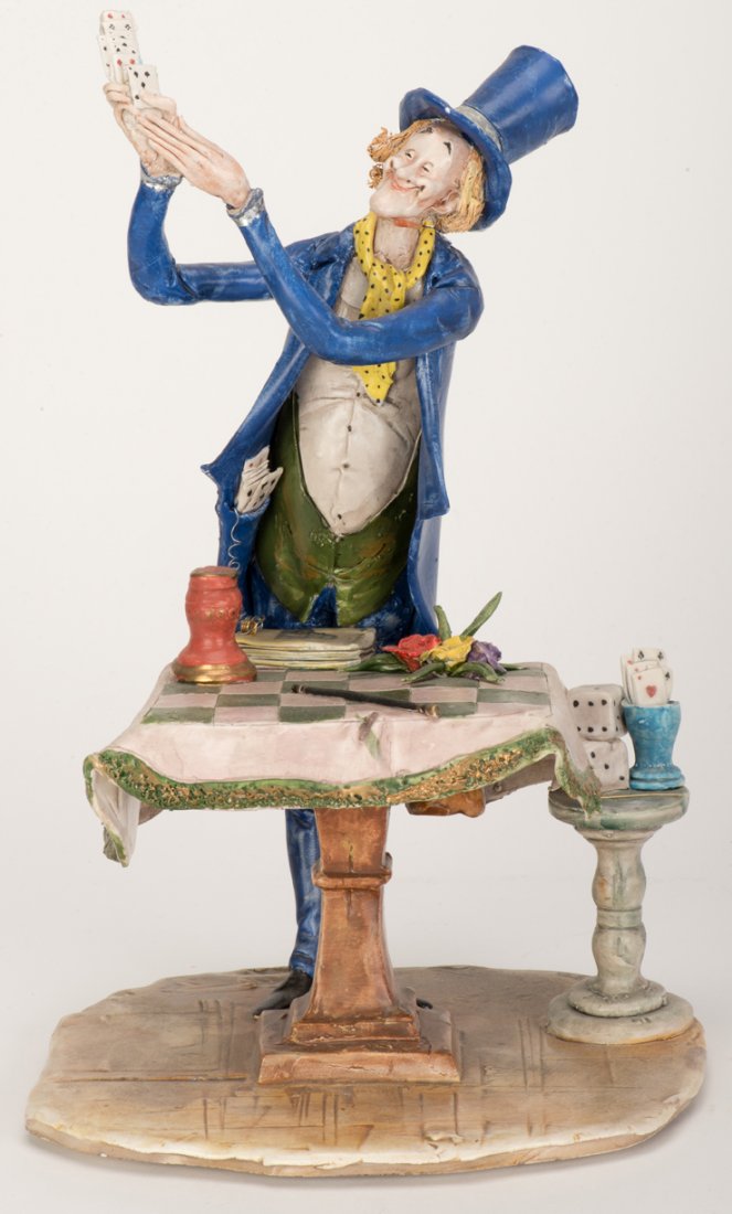 Moretto, Toni (Italian, 1929 – 2011). Magician with: Moretto, Toni (Italian, 1929 – 2011). Magician with Cards sculpture. Caricaturish depiction of a magician with cards spilling from his extended hands. A wand, flowers, magic book, and other objects