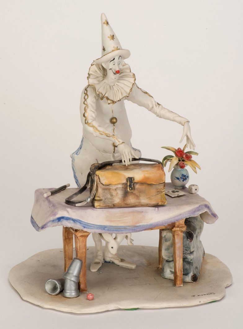 Moretto, Toni (Italian, 1929 – 2011). Clown Magician: Moretto, Toni (Italian, 1929 – 2011). Clown Magician sculpture. Pierrot-type clown magician stands behind a table. His rabbit scurries into a hole in the rear of his bag. A wand, cups and balls, and