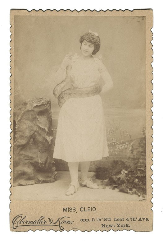 Miss Cleio Snake Charmer Cabinet Card., New York:: Miss Cleio Snake Charmer Cabinet Card., New York: Obermüller and Kern, ca. 1880. Sepia-toned cabinet card of Miss Cleio standing with a python wrapped around her torso. Lightly worn corners and some 
