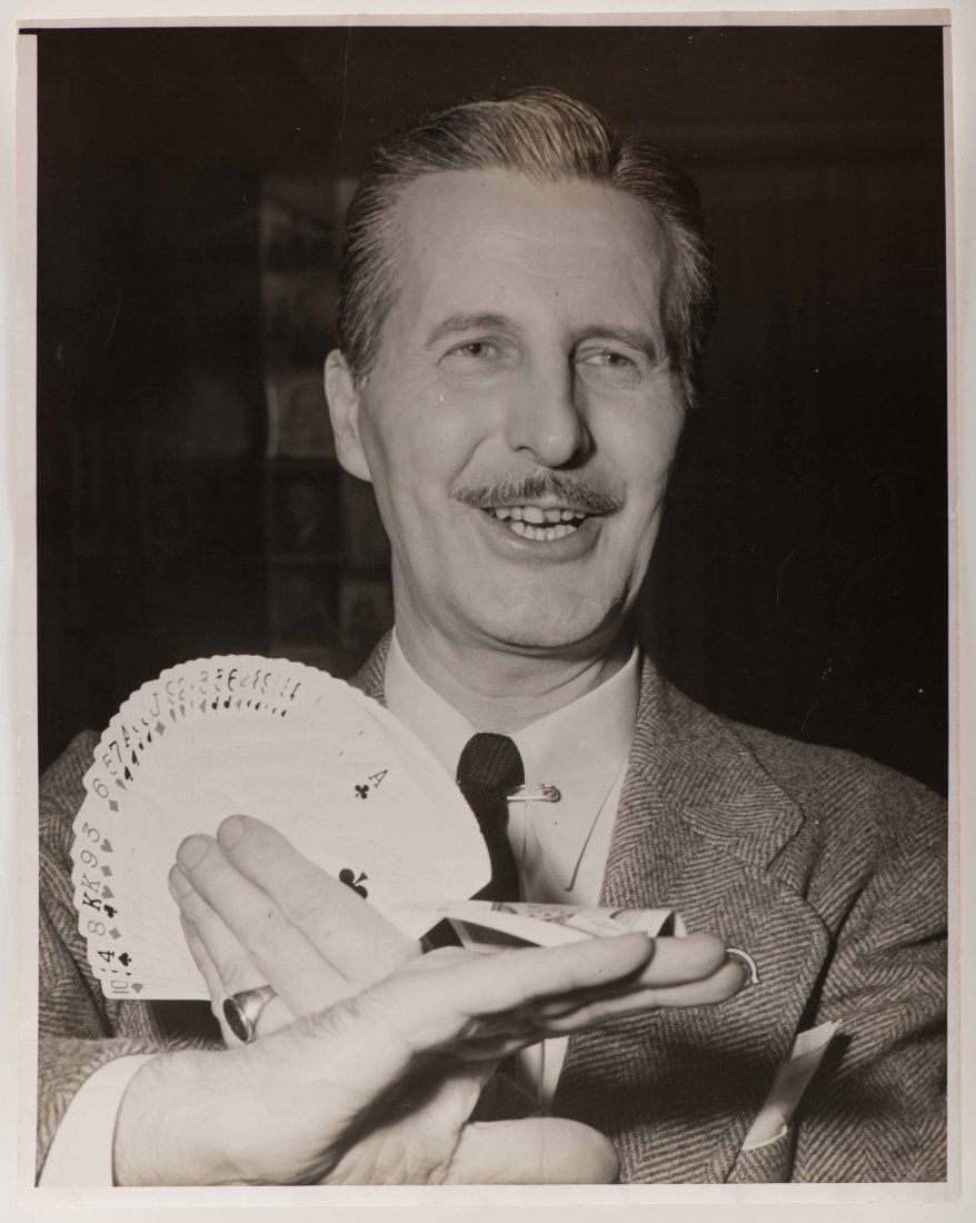 Vernon, Dai. Portrait of Dai Vernon performing the Back: Vernon, Dai. Portrait of Dai Vernon performing the Back Palm. Circa 1948. Oversize half-length portrait of The Professor in a tweed coat with a fan of cards in one hand and a back palmed card in the o
