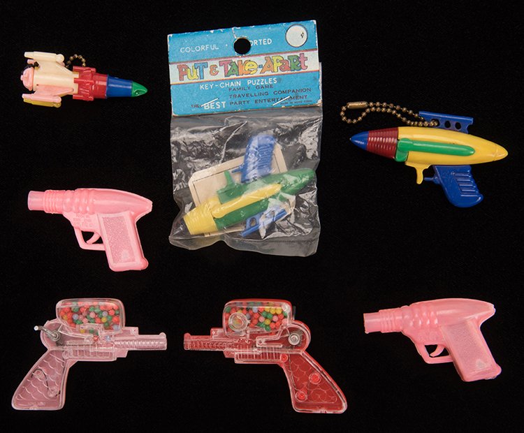 Group of Seven Ray Gun and Rocket Vintage Plastic Toys.: Group of Seven Ray Gun and Rocket Vintage Plastic Toys. Various dates and makers, mid or late twentieth century. Includes two keychains, two pencil sharpeners, one Put & Take Apart puzzle, and two toy