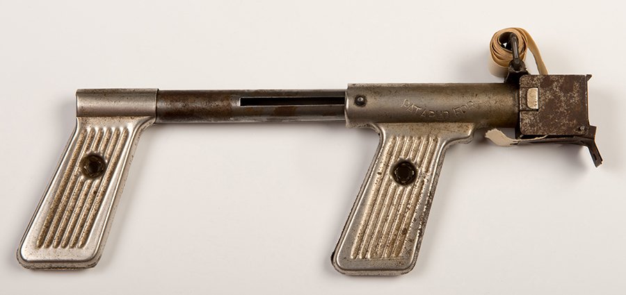 Paper Buster Gun. Mid-twentieth century. Toy paper: Paper Buster Gun. Mid-twentieth century. Toy paper buster machine gun with roll of paper loaded. 9 _ long. Widespread oxidation and scratches. Not tested. Fair.