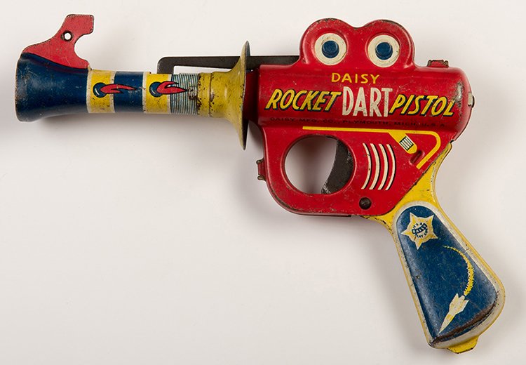 Rocket Dart Pistol. Plymouth: Daisy Manufacturing,: Rocket Dart Pistol. Plymouth: Daisy Manufacturing, mid-1950s. Brightly lithographed sheet metal toy gun, made using a mold similar to the Buck Rogers Pop Pistol from the 1930s. 7 _. Oxidation on unpai