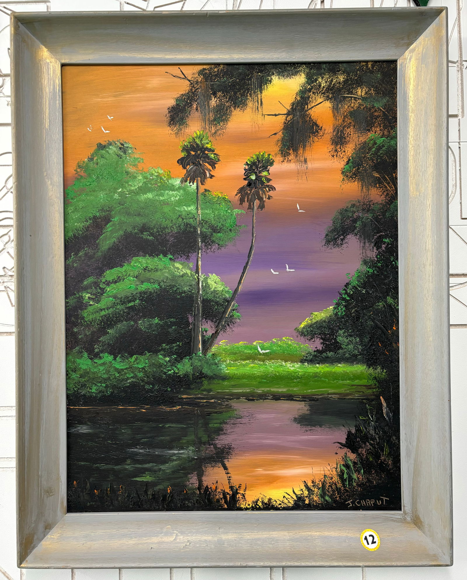 J. Chaput "Orange and Purple Back Water" 28X18 Oil Paint on Masonite, Florida Highwaymen Painting: A purple and orange fire sky reflects off of the water bed in this Florida back water scene. Features palm trees, birds, and shrubbery. Painted by Florida landscape artist, J. Chaput. Measures 29 inch