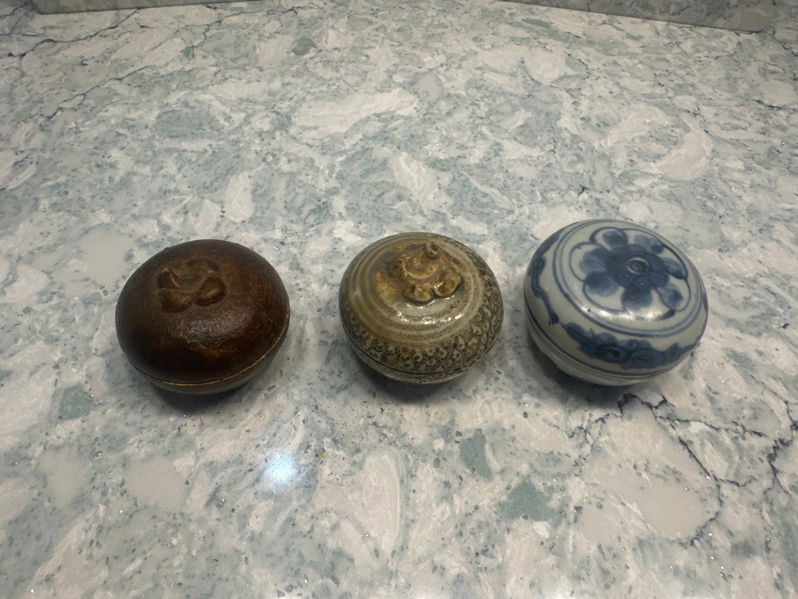 Trio of Shipwreck Medicine Jars – Chinese, Thai, and Southeast Asian: A group of three lidded medicine jars representing major traditions of Southeast Asian maritime trade. Includes one Kangxi period Chinese blue-and-white porcelain box (c.1690), one Thai celadon-glazed
