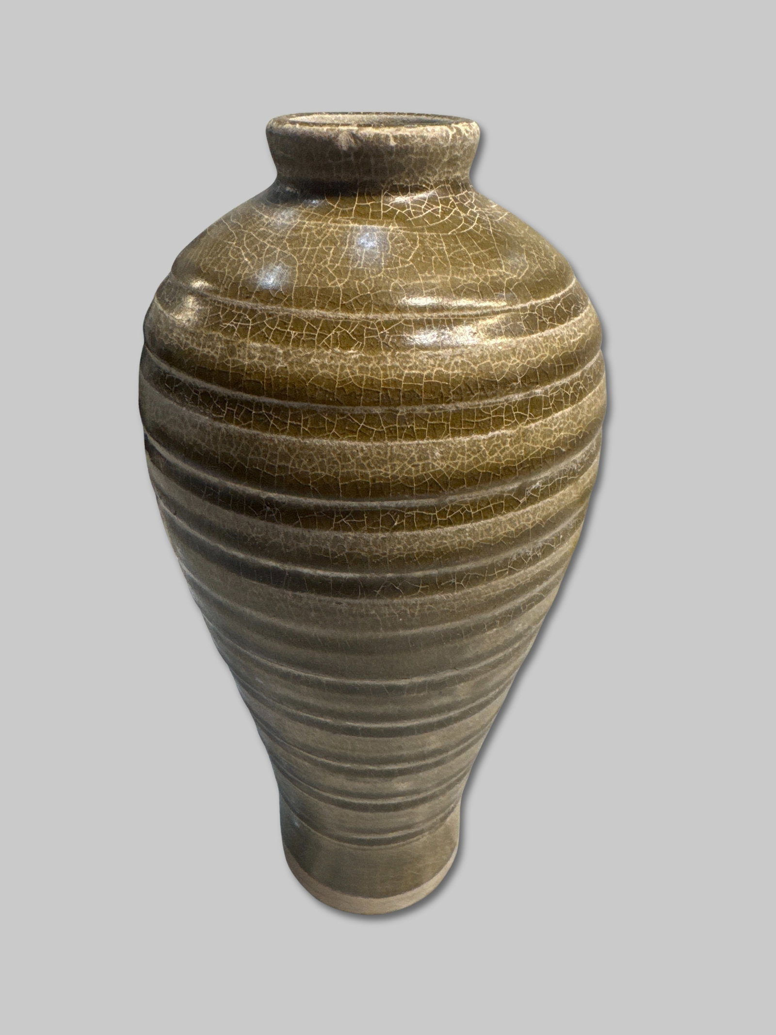 Crackle-Glazed Ribbed Bottle with Narrow Mouth 4 3/8" x 11 1/2": Finely thrown tall bottle-form jar with a narrow mouth and rounded shoulders tapering to a stable foot. The surface is covered in a warm, olive-toned glaze with elegant all-over crackle and precisely 
