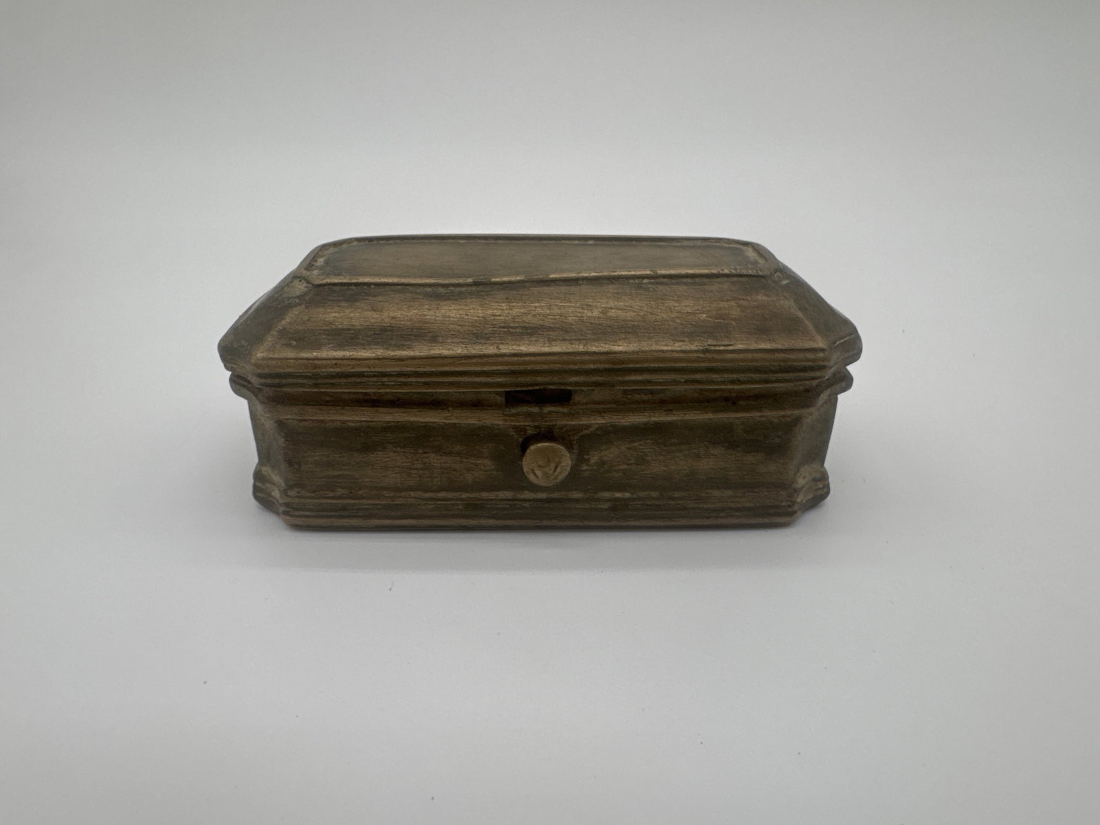 Small Bronze/Brass/Pewter? Coffin-Shaped Trinket Box4" x 1.75" x 1.375": Antique coffin-shaped trinket box, likely cast in brass or bronze with worn patina and aged oxidation. The box features beveled edges and a hinged lid, and has likely served as a small valuables holde