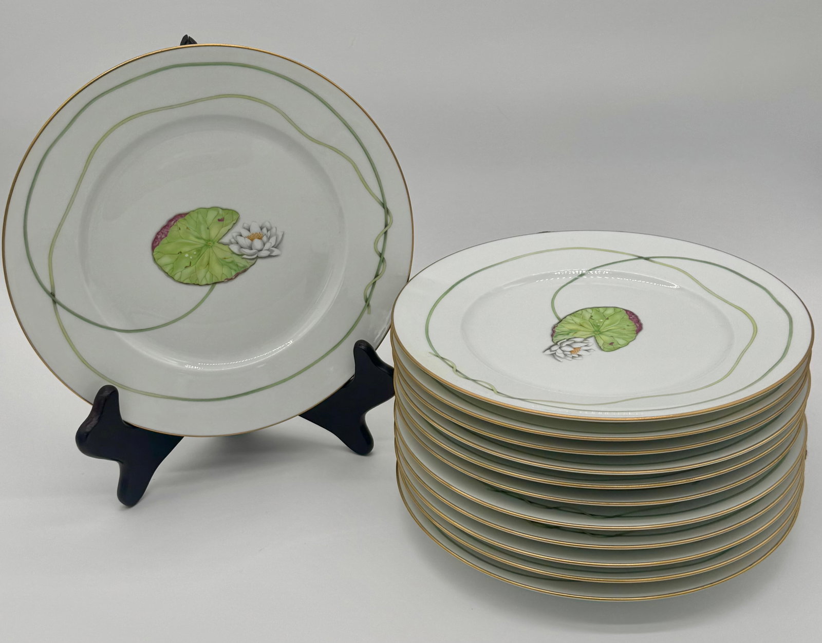 Set of Twelve Hermès NIL Porcelain Waterlilly Dinner Plates- 10.75”: "A complete set of twelve Hermès NIL porcelain dinner plates, each measuring 10 3/4 inches in diameter and approximately 7/8 inch high. These large-format plates feature a vibrant green Waterlilly an