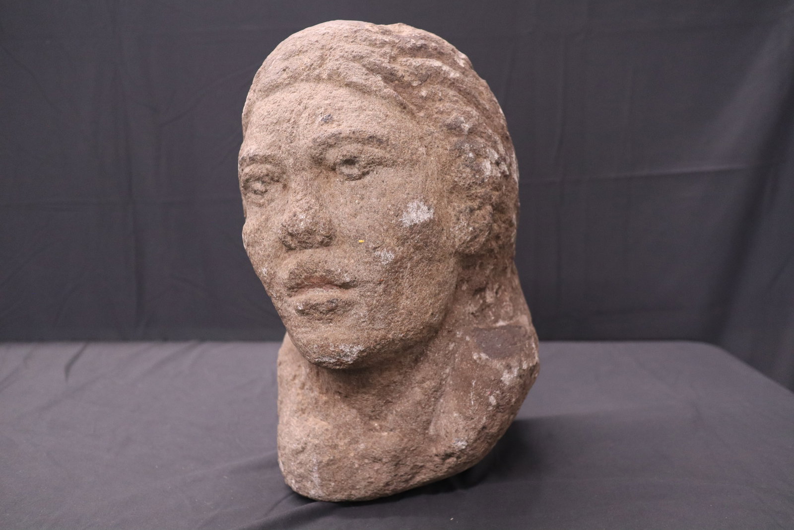 Heavy Stone Head Sculpture – Hand-Carved Bust, 15 × 8.5 inches: Solid stone, hand-carved into a stylized bust depicting a human head with detailed facial features including defined brow, eyes, nose, lips, and textured hair. The carving style is rustic, with an int