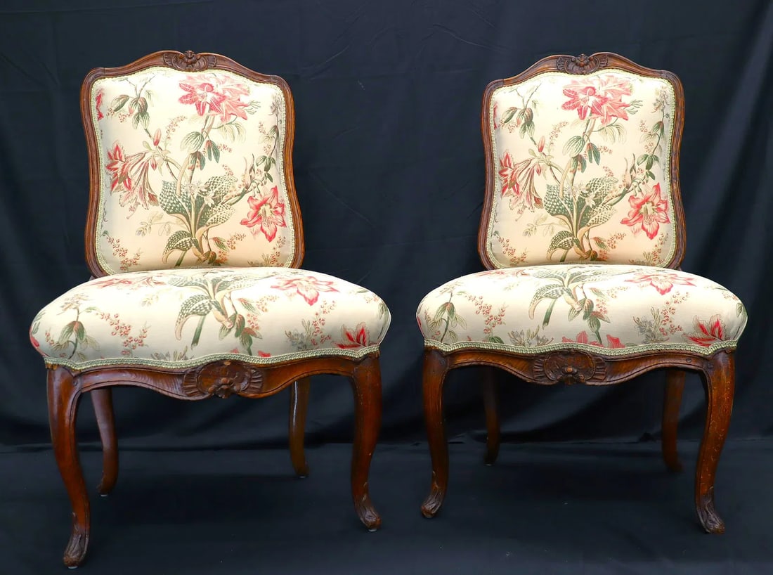 Pair of Louis XV Style Walnut Side Chairs with Carved Shell Crest 24"X37": A refined pair of Louis XV style side chairs in carved walnut, likely late 19th century. The frames feature elegant Rococo lines with hand-carved shell and floral motifs on the crest rail and seat apr
