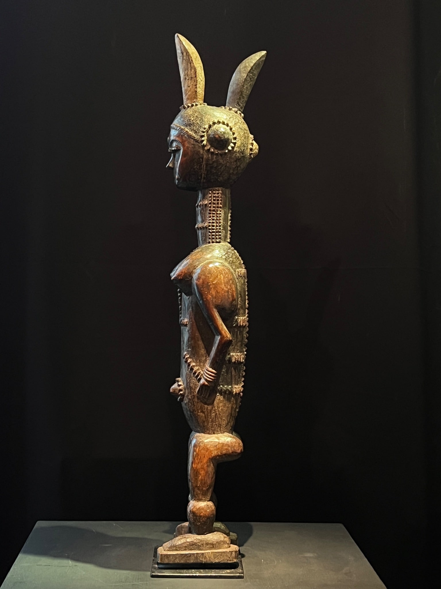 Ivory Coast, 20th century Attié statue Wood, pigments H75 cm A slender statue depicting a standing: Ivory Coast, 20th centuryAttié statueWood, pigmentsH75 cmA slender statue depicting a standing figure with a very elongated body; the torso and neck are entirely adorned with layers of relief and inc