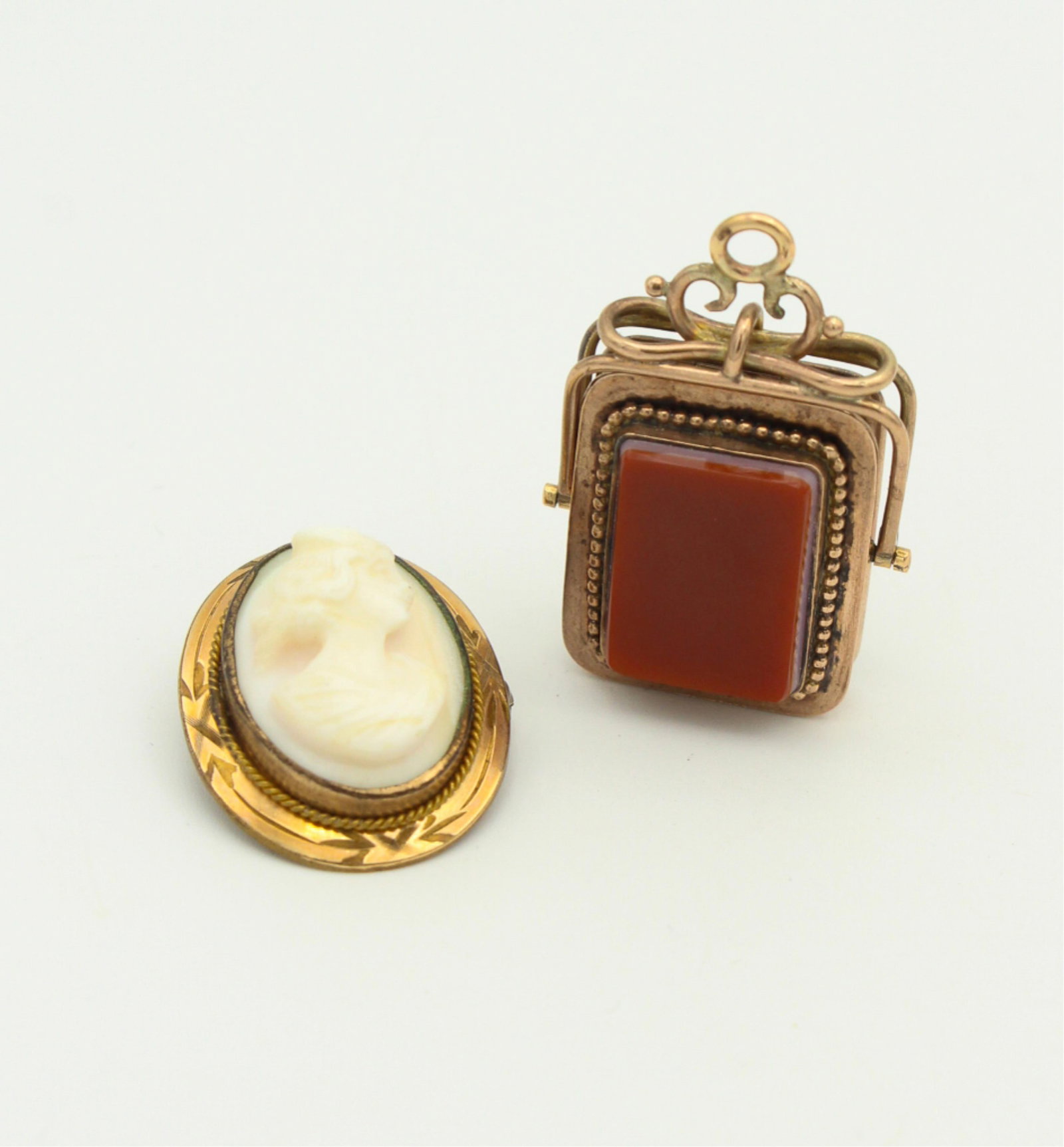 Victorian Pendants: Victorian Pendants One Gold filled brooch with beautiful cameo 1" in length, excellent condition. One gold filled pendant with ornate bale that opens. One side is carnelian and one side is onyx.