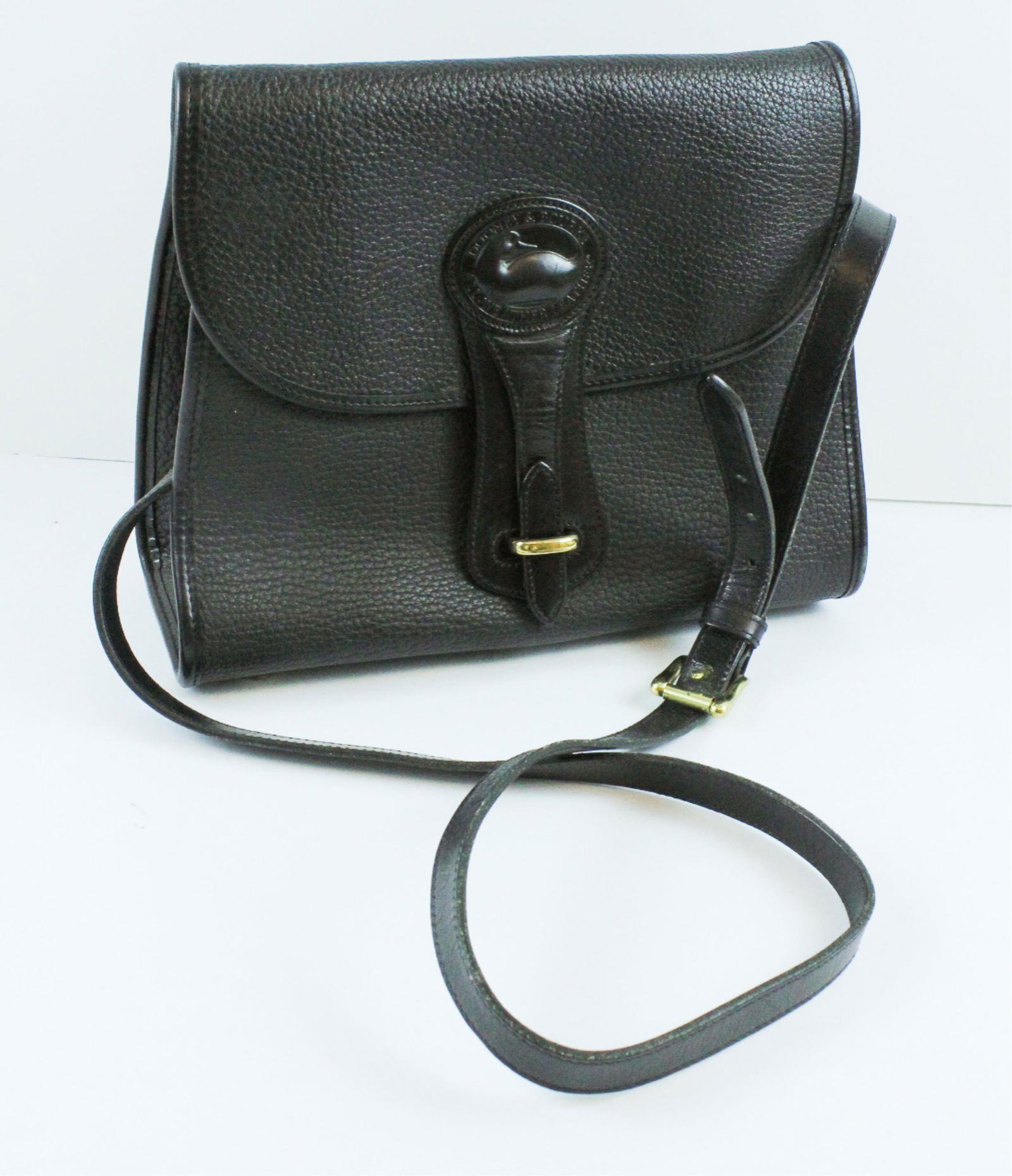 Dooney & Bourke Black Leather Handbag With Shoulder Strap: Dooney & Bourke Black Leather Handbag With Shoulder StrapA classic Dooney & Bourke shoulder bag with a lovely pebbled leather finish in inky black, gold tone hardware, suede interior and polished leat