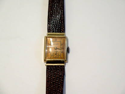 Baume & Mercier Banner Precision Watch: Runs and keeps time. 14kt. gold case with rose gold face. Original leather bracelet. Swiss made mechanical hand wind movement. Minor scratches on crystal and reverse. Marked 14 karat gold with LD cres