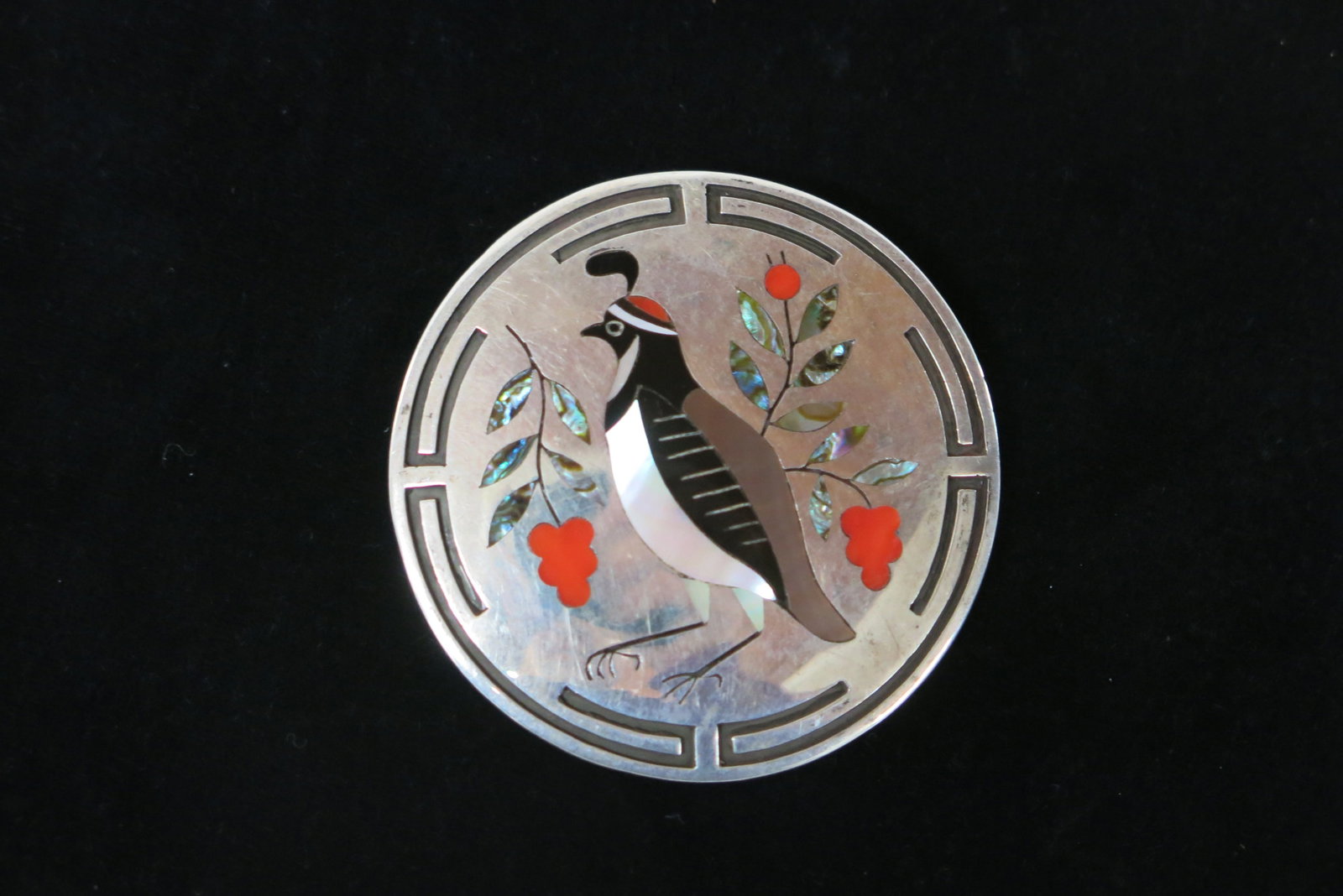 Dennis and Nancy Edaakie Zuni Quail Brooch: Stamped signature on reverse. The piece utilizes precise stone-to-stone and channel inlay techniques. Sterling silver, Mother of Pearl and jet for the bird's body, red coral for the berries, black jet