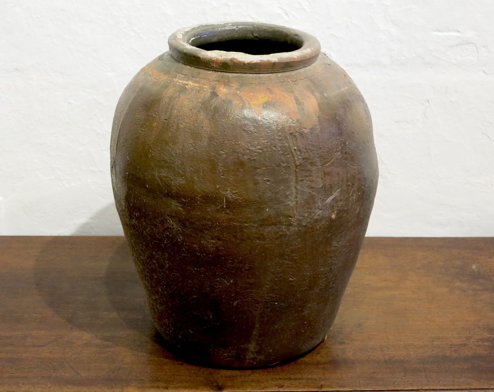 Vintage Chinese Glazed Ceramic Martaban Jar: The jar is made of durable, rustic stoneware or earthenware. It is largely unglazed, with the patina resulting from the natural ash glaze created during the high-temperature wood-firing process known