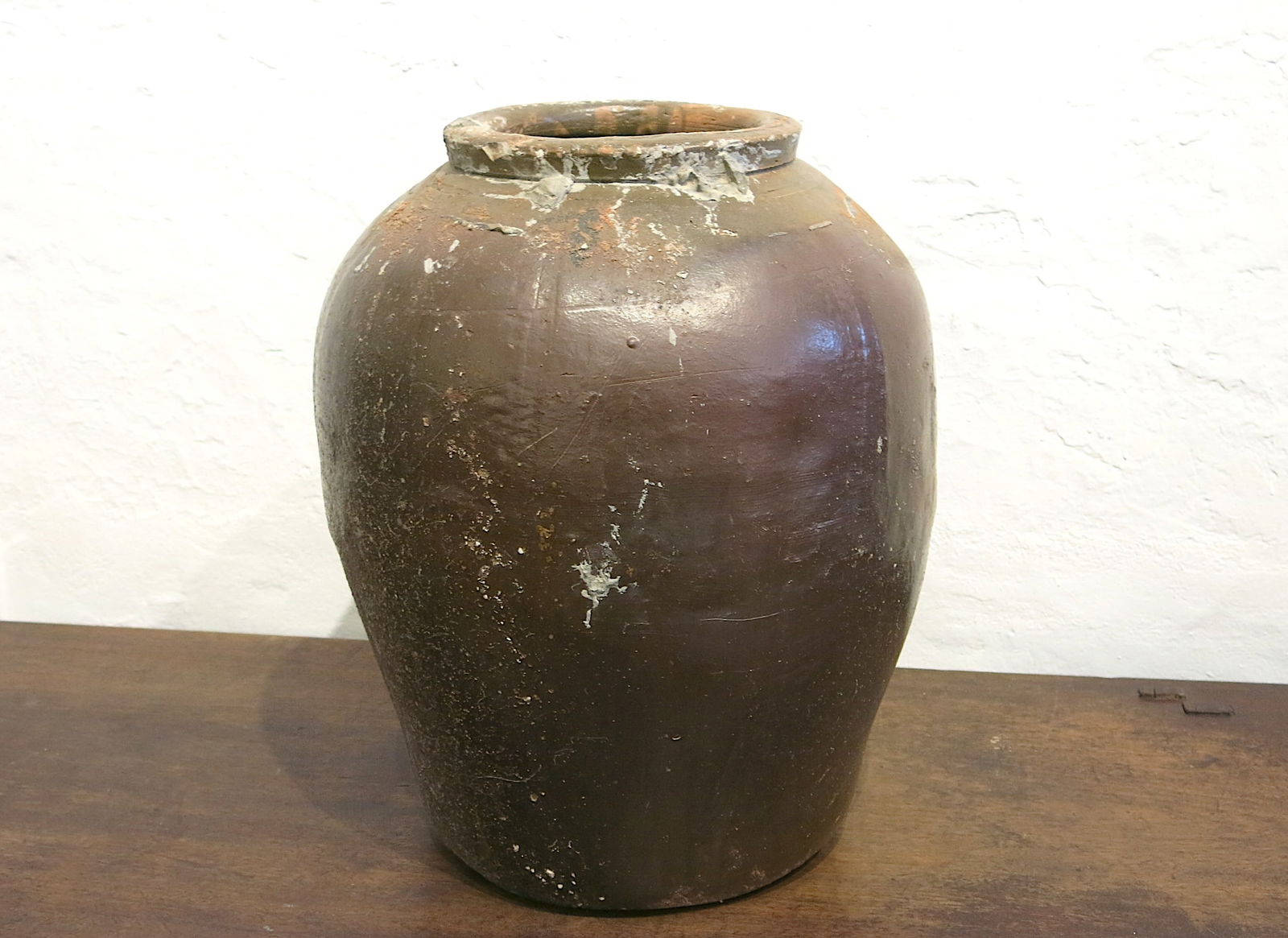 Vintage Chinese Glazed Ceramic Martaban Jar: The jar is made of durable, rustic stoneware or earthenware. It is largely unglazed, with the patina resulting from the natural ash glaze created during the high-temperature wood-firing process known