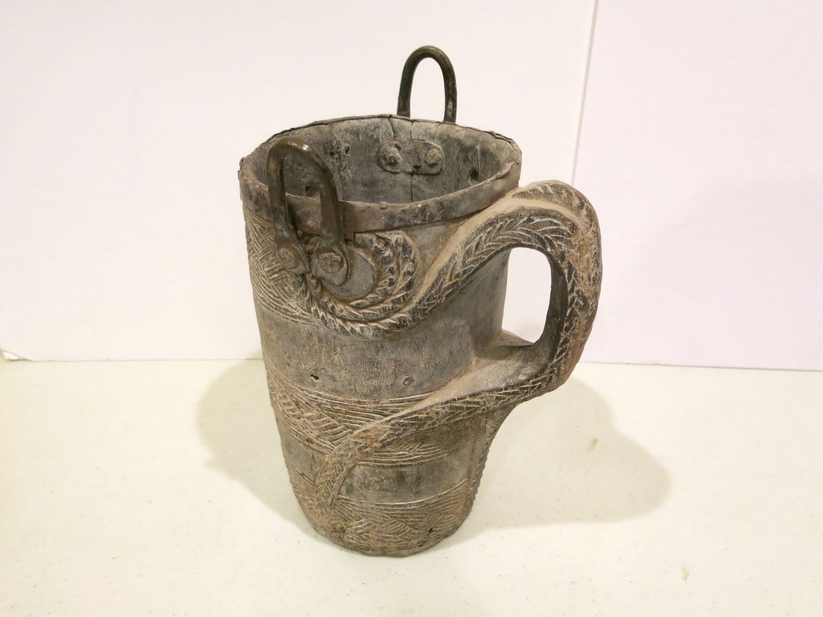 Early 19th C. Tibetan Yak Milk Bucket: Coiled rope motif spirals from jug to expand into a thick handle. Metal straps were applied later to accomodate a strap or staff. These vessels were utilitarian items handcrafted by local tribal peopl
