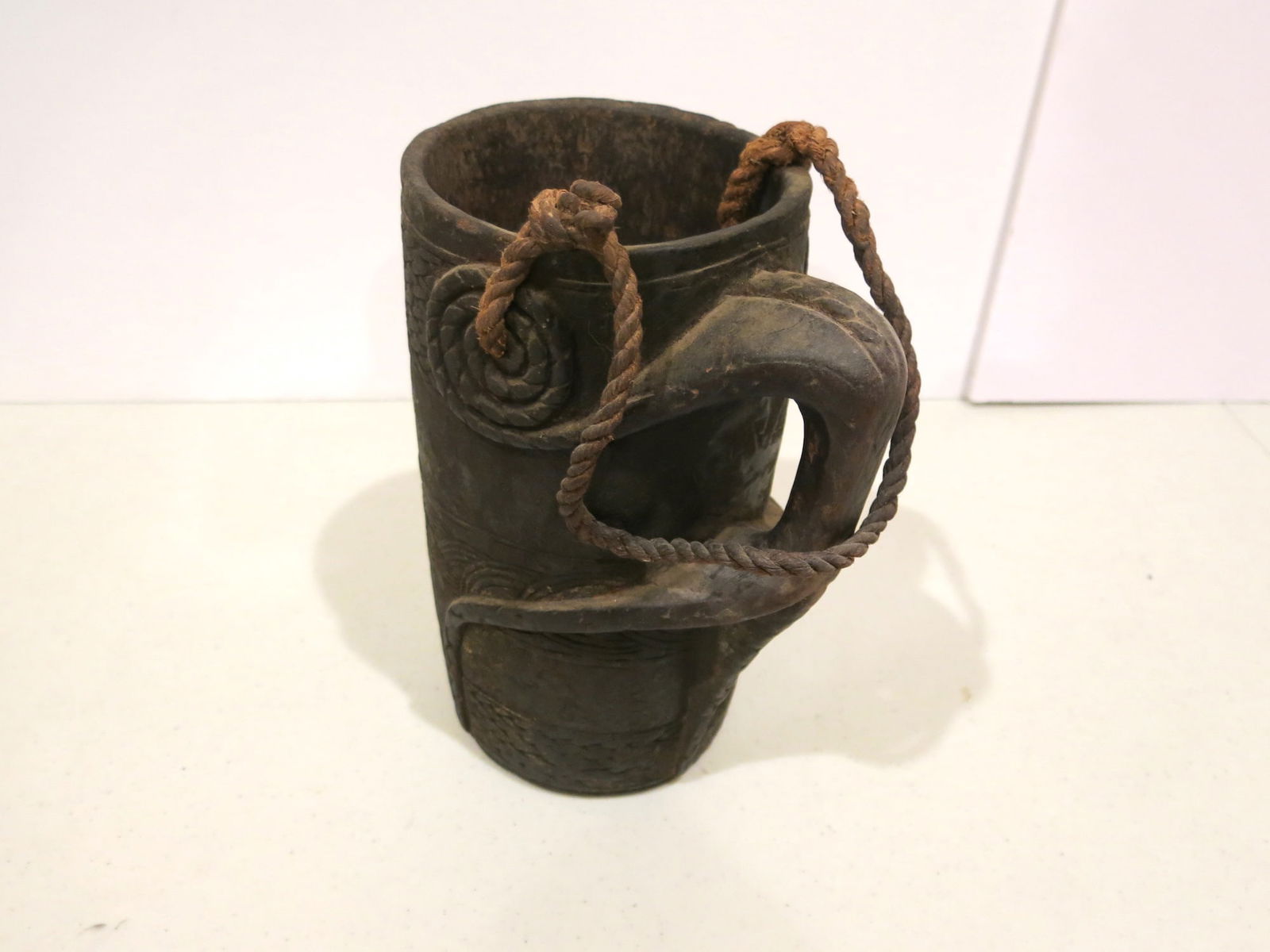 Early 19th C. Tibetan Yak Milk Bucket: Coiled rope motif spirals from jug to expand into a thick handle. Metal straps were applied later to accomodate a strap or staff. These vessels were utilitarian items handcrafted by local tribal peopl