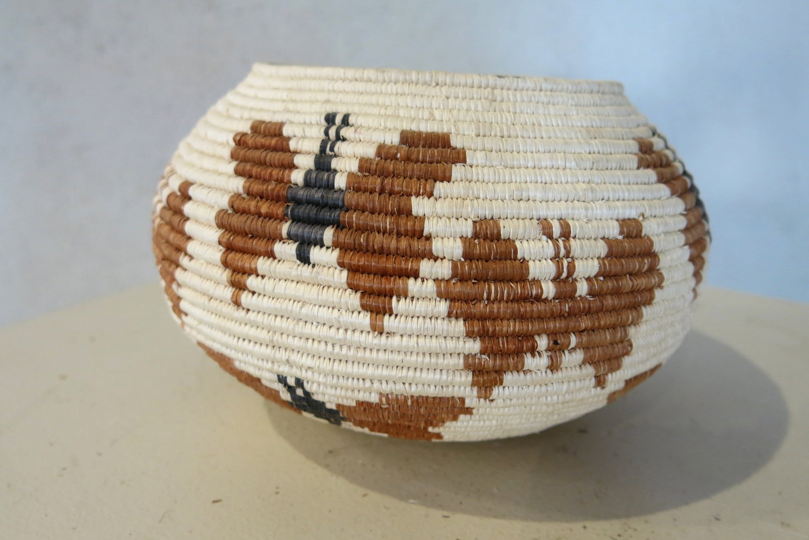 Tri-Color Seri Indian Butterfly Basket: A Seri (Comcaac) Indian basket is a hand-coiled textile art form created by the indigenous Seri people of Sonora, Mexico. Once used for functional tasks like gathering desert fruits or carrying water,