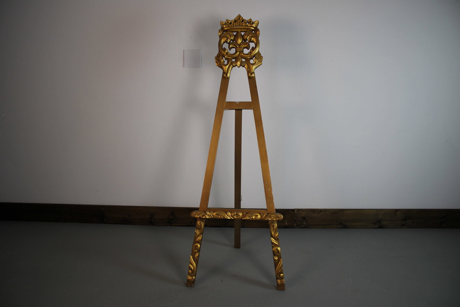 Italian Style Gilded Carved Wood Art Display Easel 57"x20": A large-scale giltwood display easel with a pierced fleur-de-lis crest terminating in a gilded crown finial. The tripod legs cross at the crest and splay to a carved lower stretcher flanked with acant