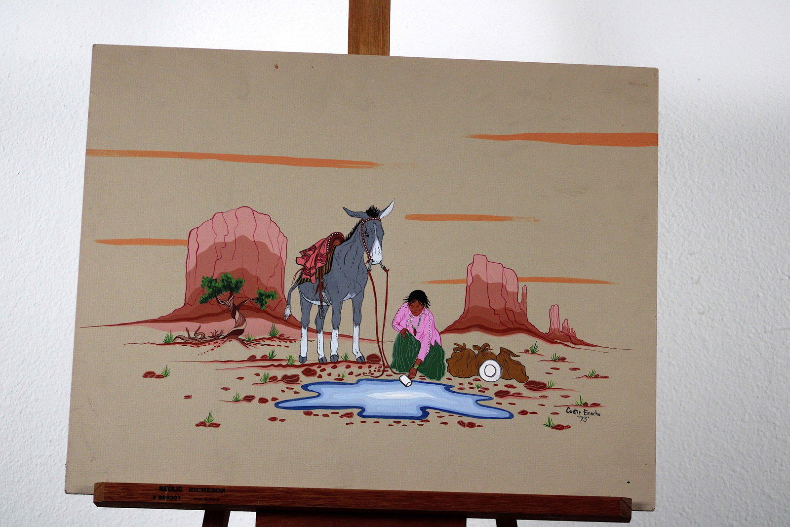 Curtis Eriacho Zuni Drink at Old Spring 1973: Original acrylic painting on mat board by Zuni artist Curtis Eriacho, titled "Getting a Drink at the Old Spring" and dated 1973. The composition depicts a young Native girl in a pink blouse and green 