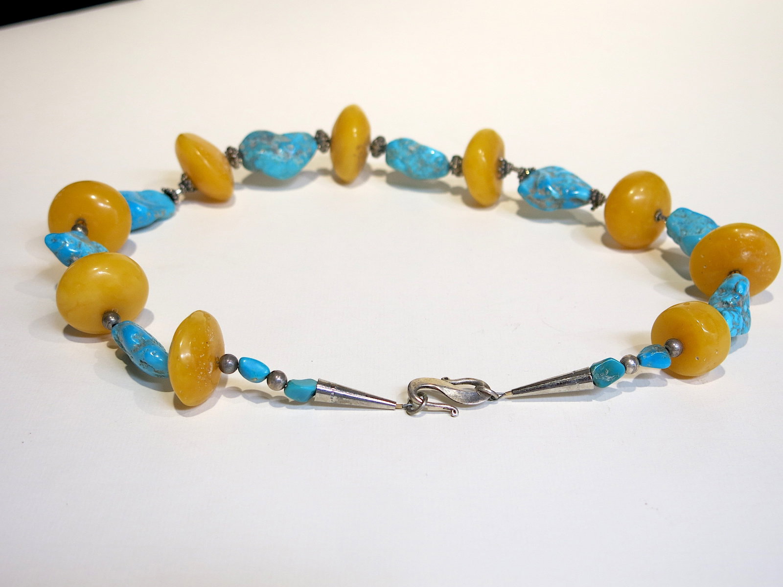 Southwestern Turquoise & Amber Bead Necklace: Handcrafted artisan bead necklace alternating large flat round amber-colored resin beads with polished turquoise nugget beads and irregular turquoise chunks, separated by ornate Bali-style granulated 