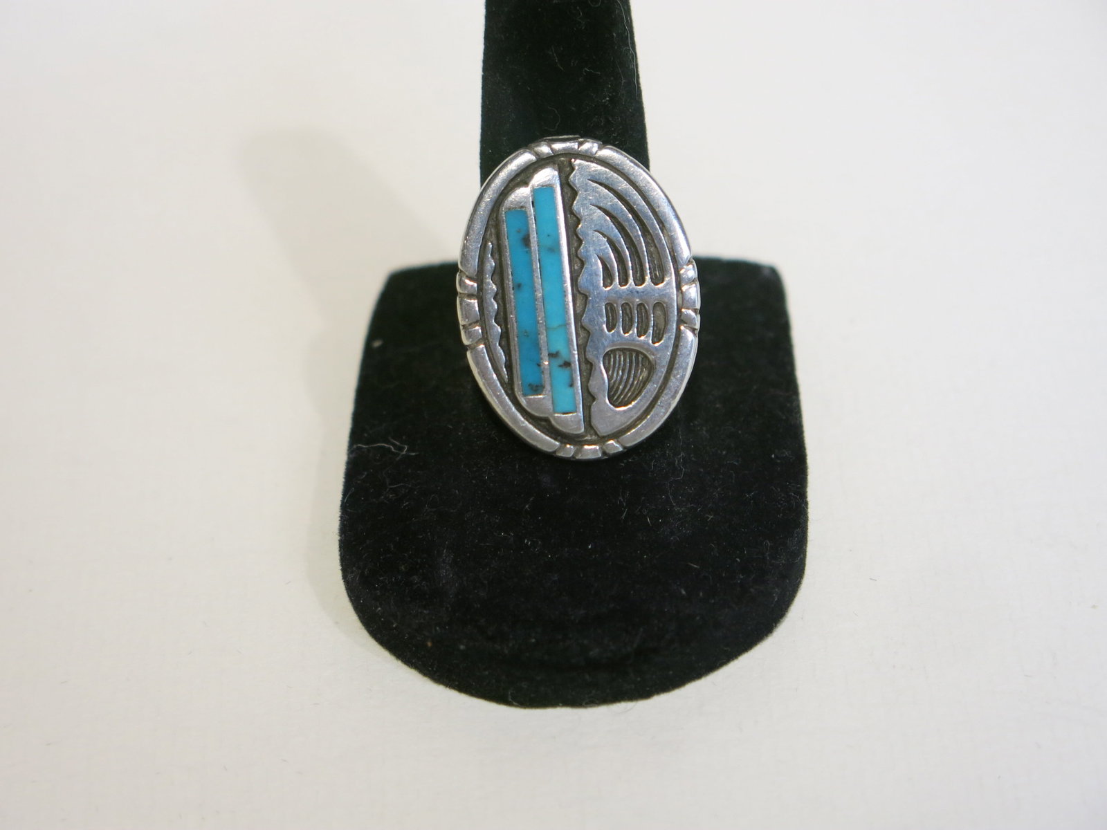 Navajo Sterling Bear Paw Ring with Turquoise: Vintage Southwestern sterling silver ring, oval face split into two design halves. The left half holds two vertical rectangular turquoise inlay bars set flush within a stepped silver border; the right