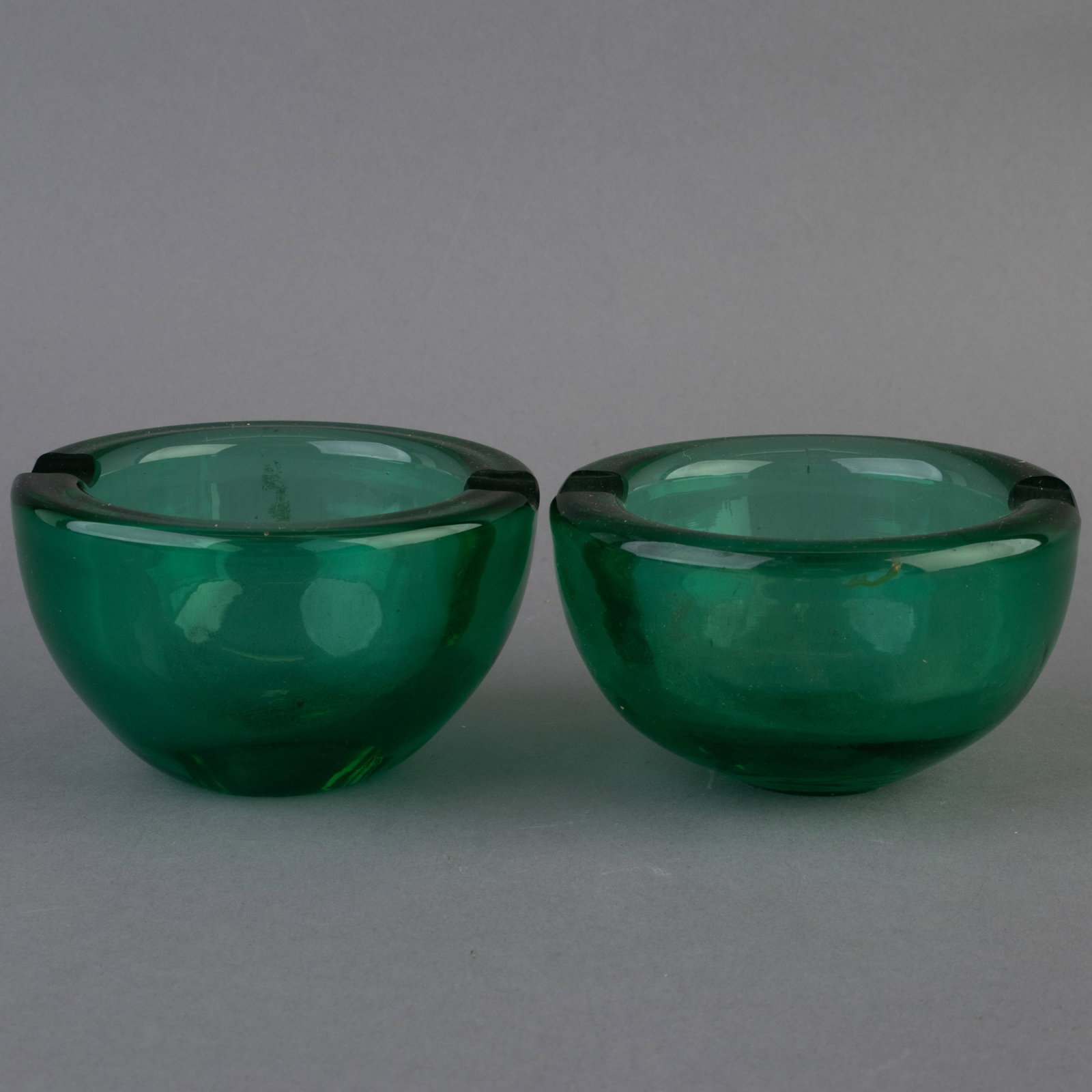 PAIR OF MID CENTURY MURANO HAND BLOWN GREEN GLASS ASHTRAYS: From a collection of Wedgwood and other selected ceramic/porcelain objects. Kindly examine all photographs provided in this listing or ask for a condition report. All items offered are in generally go
