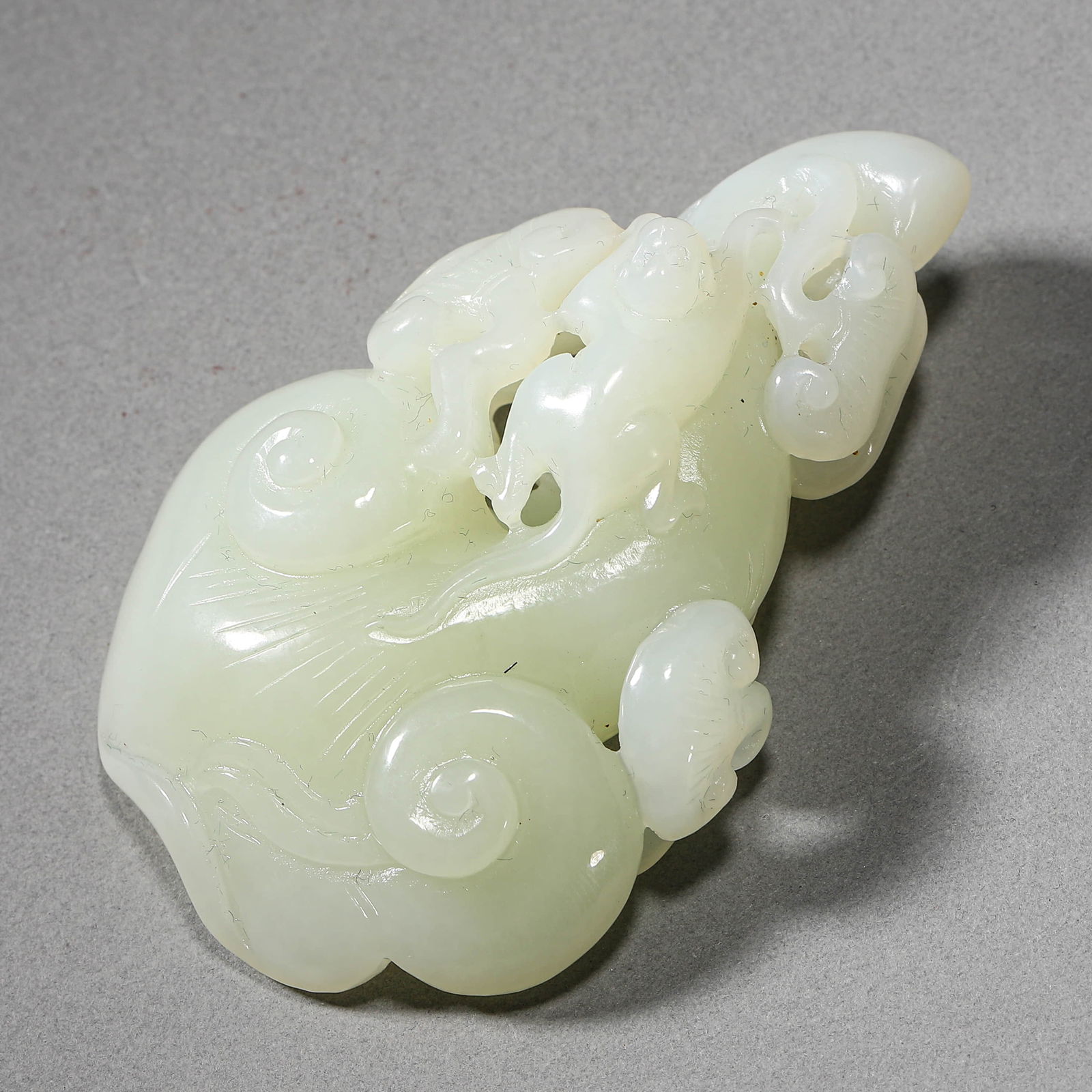 A CHINESE WHITE JADE CARVING OF A LINGZHI FUNGUS.: A CHINESE WHITE JADE CARVING OF A LINGZHI FUNGUS. Length: 2 3/4 in. (7 cm), Width: 1 3/4 in. (4.5 cm) Condition: Any statement made in any catalogue or otherwise regarding the origin, date, age, attri