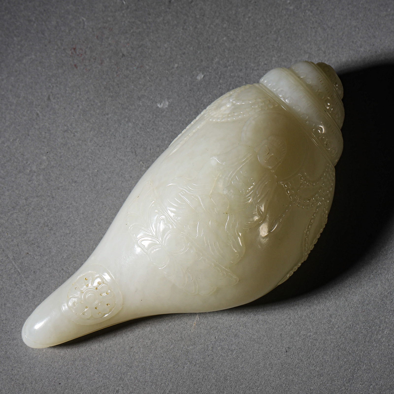 A CHINESE WHITE JADE CONCH.: A CHINESE WHITE JADE CONCH. Length: 4 15/16 in. (12.5 cm) Condition: Any statement made in any catalogue or otherwise regarding the origin, date, age, attribution, authenticity, or estimated selling p