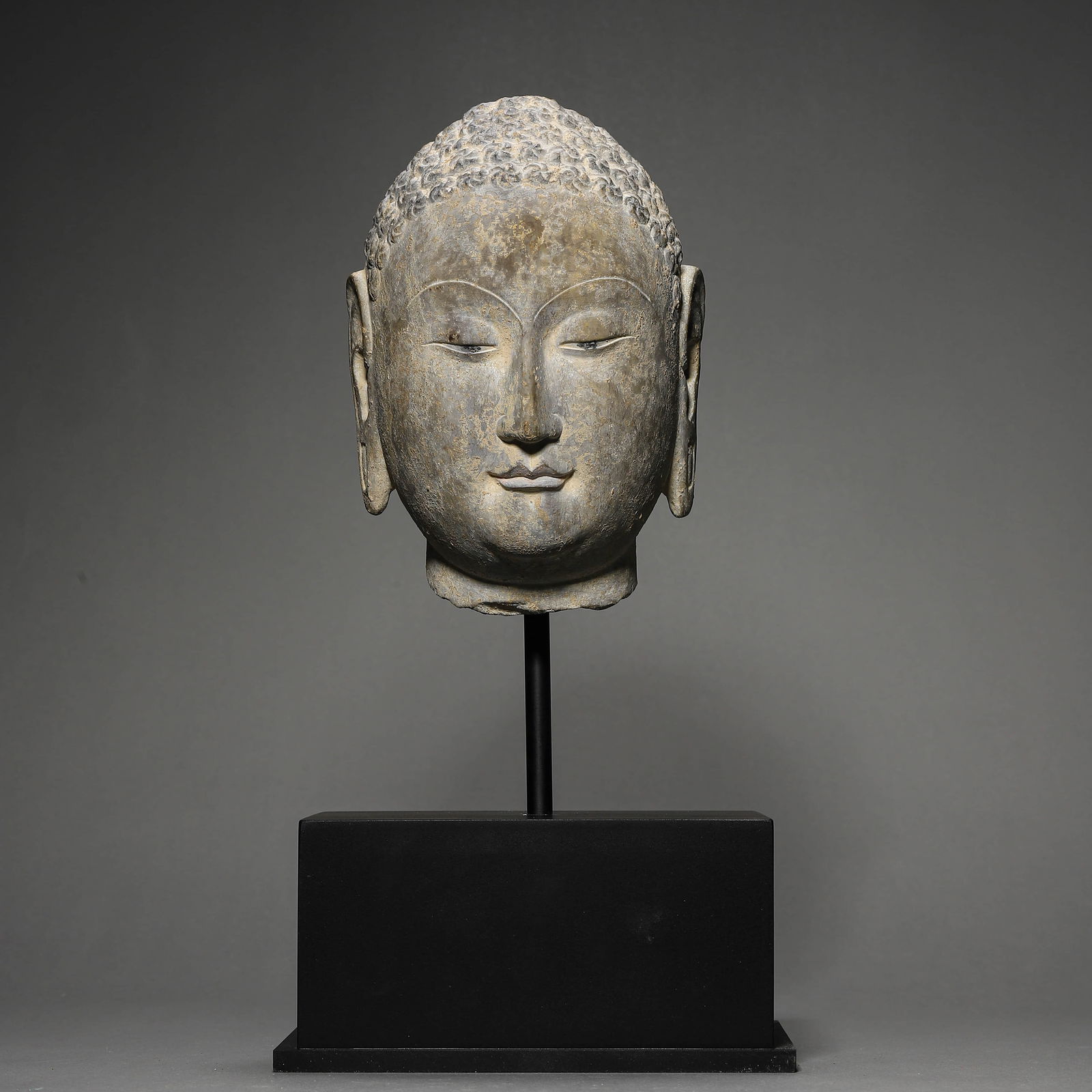 A CHINESE STONE CARVING OF A BUDDHA'S HEAD. (1 of 3)