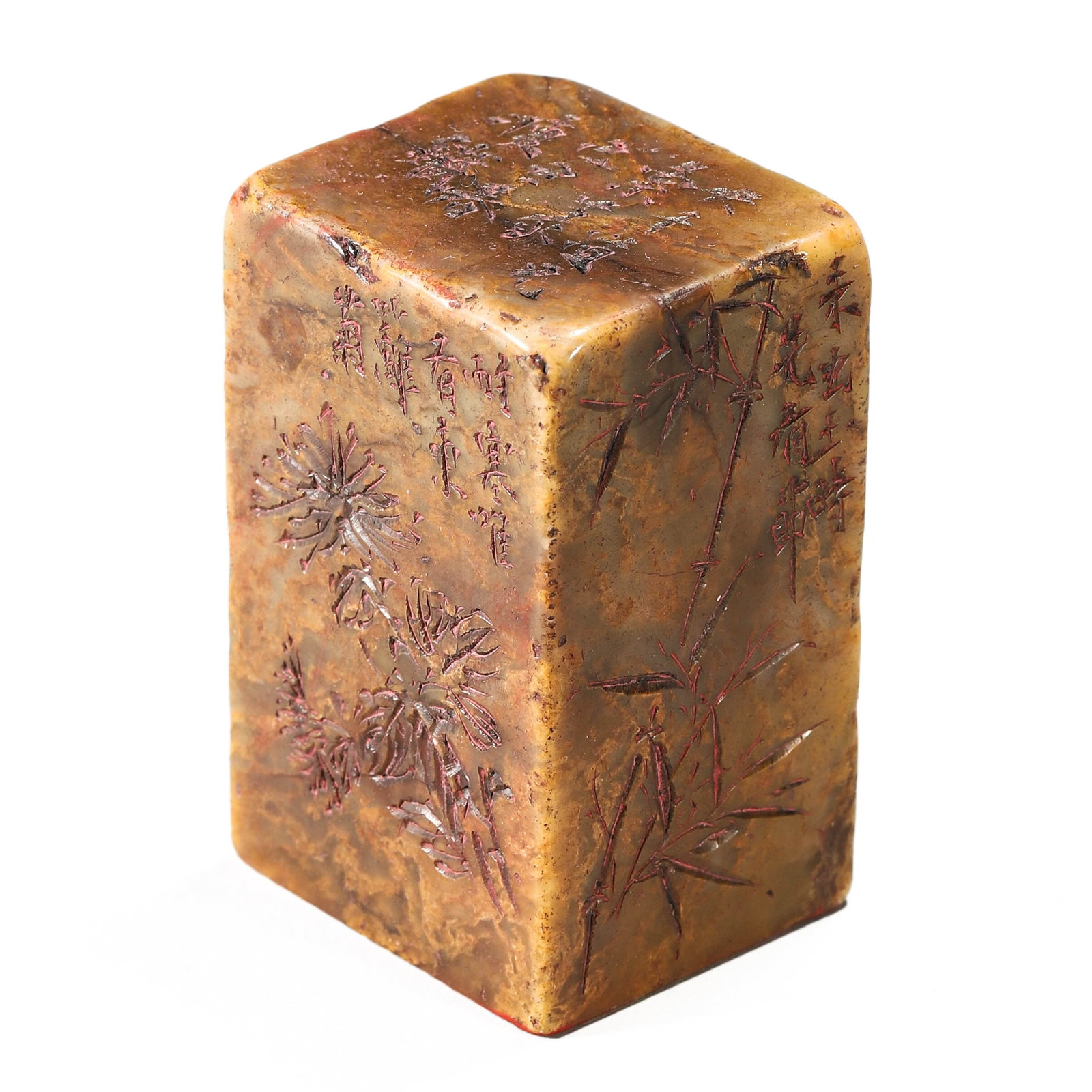 A CHINESE SHOUSHAN STONE SEAL, CARVED WITH THE FOUR GENTLEMEN: Dimensions: Height: 2 11/16 in (6.8 cm), Seal face: 1 1/2 × 1 11/16 in (3.7 × 4.3 cm) The seal is carved from warm-toned Shoushan stone with mottled ochre and russet hues. All sides are finely incis