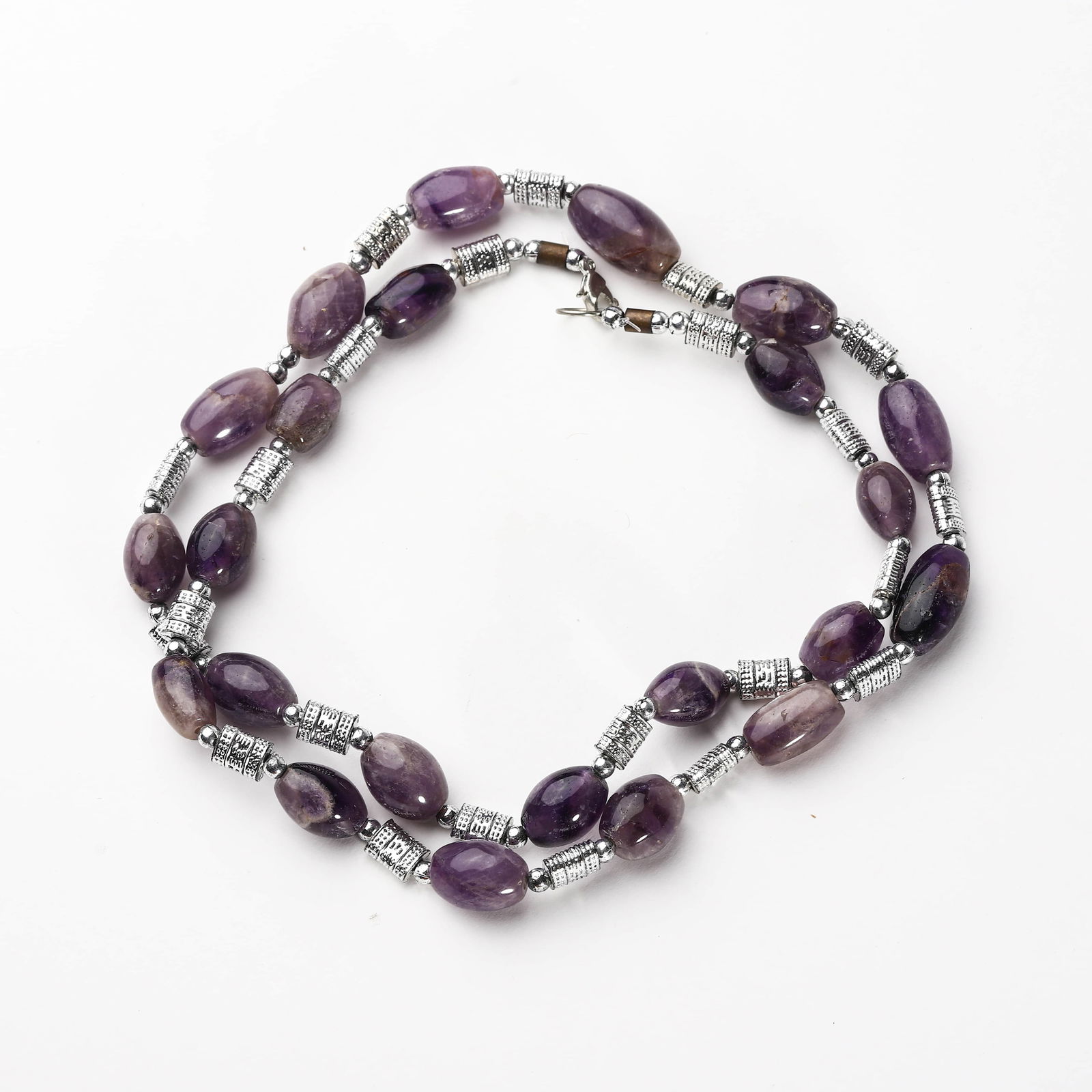AMETHYST AND METAL BEAD NECKLACE: Dimensions: Length: 13 3/4 in. (35 cm) Description: This elegant necklace features polished, oval-shaped amethyst beads interspersed with intricately engraved silver-tone metal spacers. The amethysts