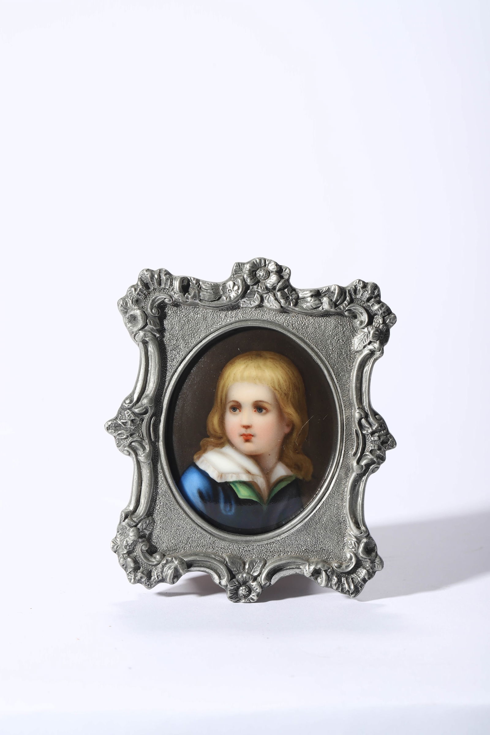 ROYAL SELANGOR, MALAYSIA — A HAND-PAINTED PORCELAIN PORTRAIT MINIATURE IN A PEWTER FRAME.: ROYAL SELANGOR, MALAYSIA — A HAND-PAINTED PORCELAIN PORTRAIT MINIATURE IN A PEWTER FRAME. Frame size: approx. 4 × 3 in. (10 × 7.5 cm). Description: A finely painted porcelain miniature depicting a