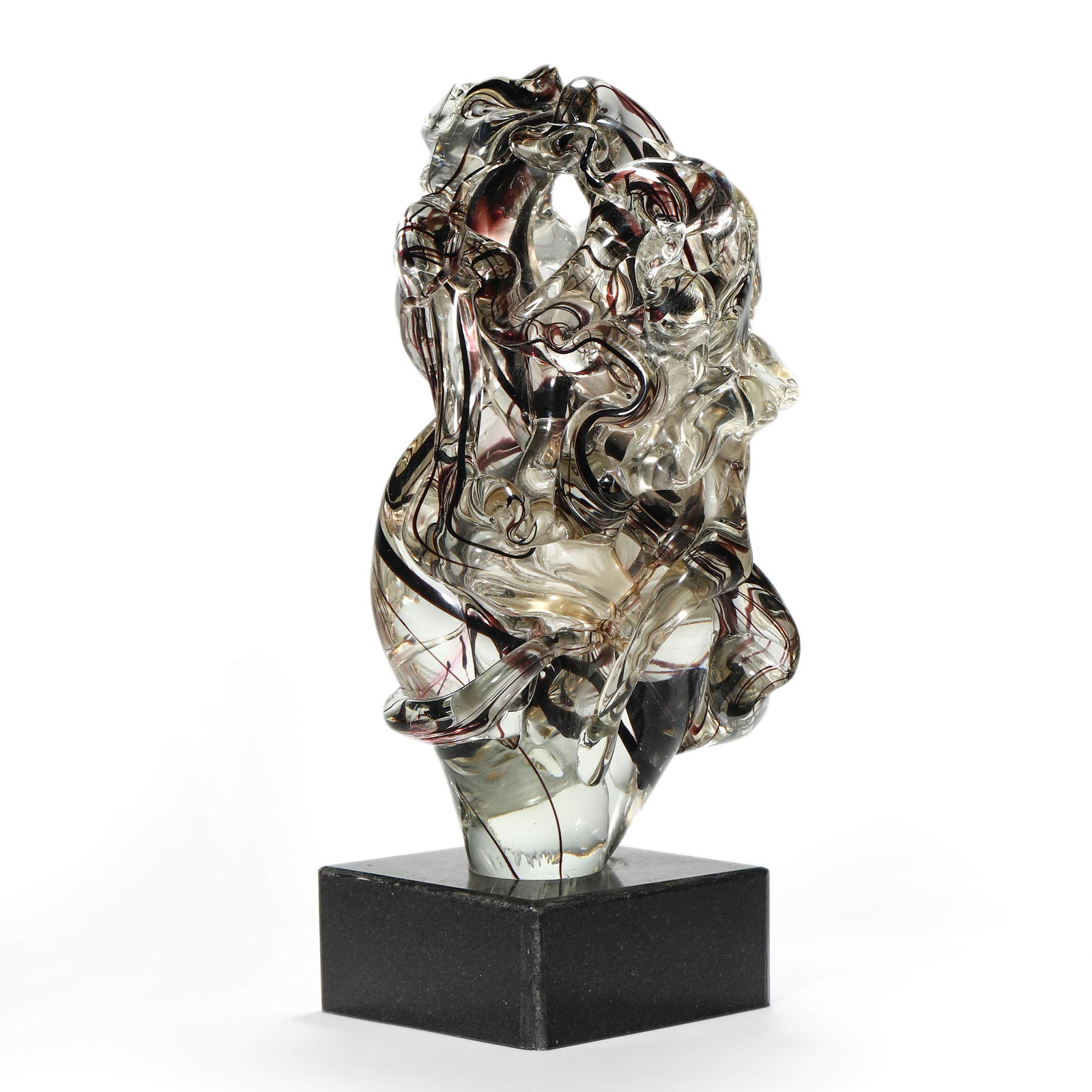A CONTEMPORARY GLASS SCULPTURE ON BLACK STONE BASE: Dimensions: Height with base: 16 15/16 in. (43 cm); Height without base: 14 3/8 in. (36.5 cm) Description: A dynamic contemporary glass sculpture characterized by fluid, intertwined forms and intricat