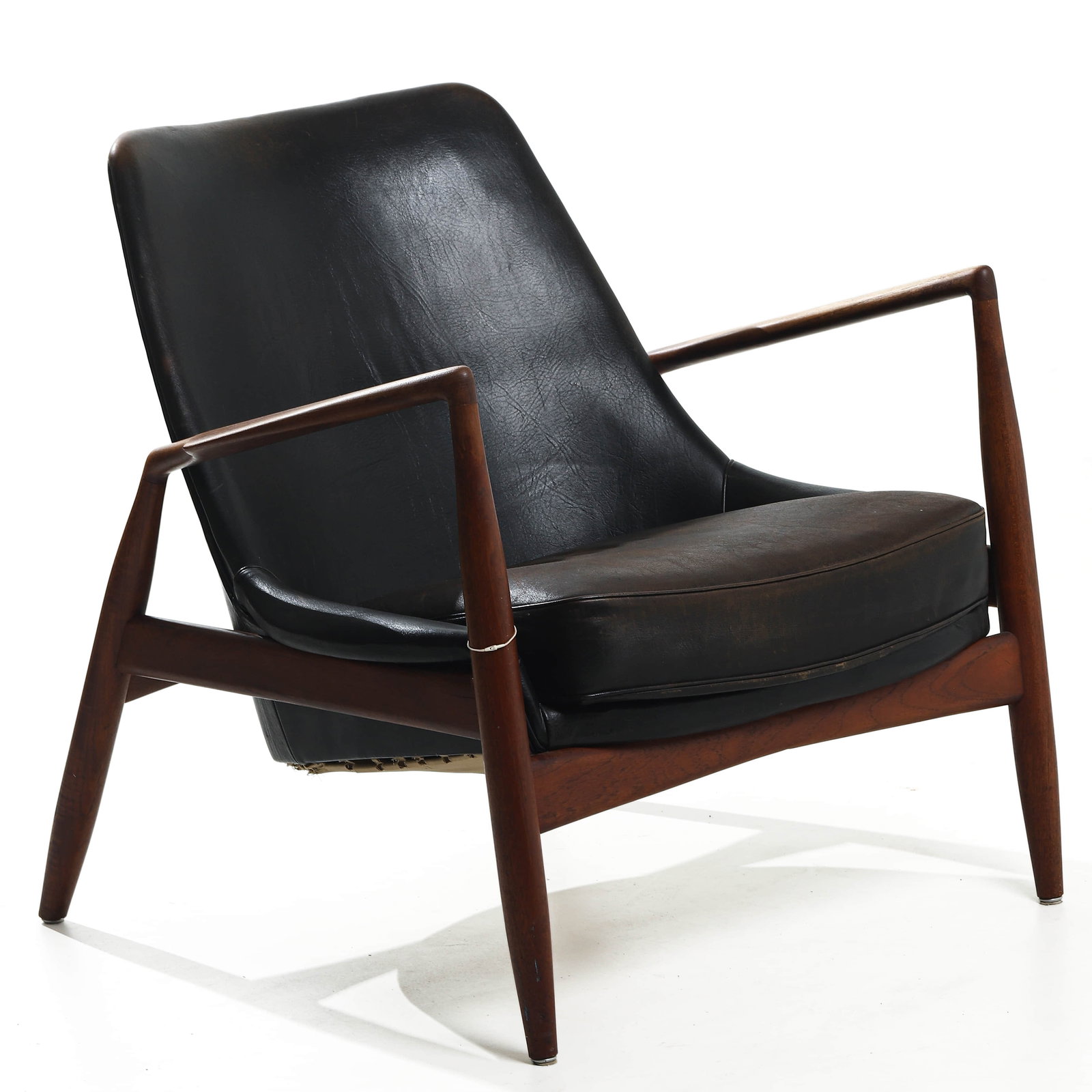 IB KOFOD-LARSEN “SEAL?? LOUNGE CHAIR FOR OPE, TEAK AND LEATHER: Dimensions Height 29 1/2 in. (75 cm), Seat height 15 3/8 in. (39 cm), Width 31 1/2 in. (80 cm) Description Designed in 1956 by Danish designer Ib Kofod-Larsen and produced by OPE in Sweden, the “Sea