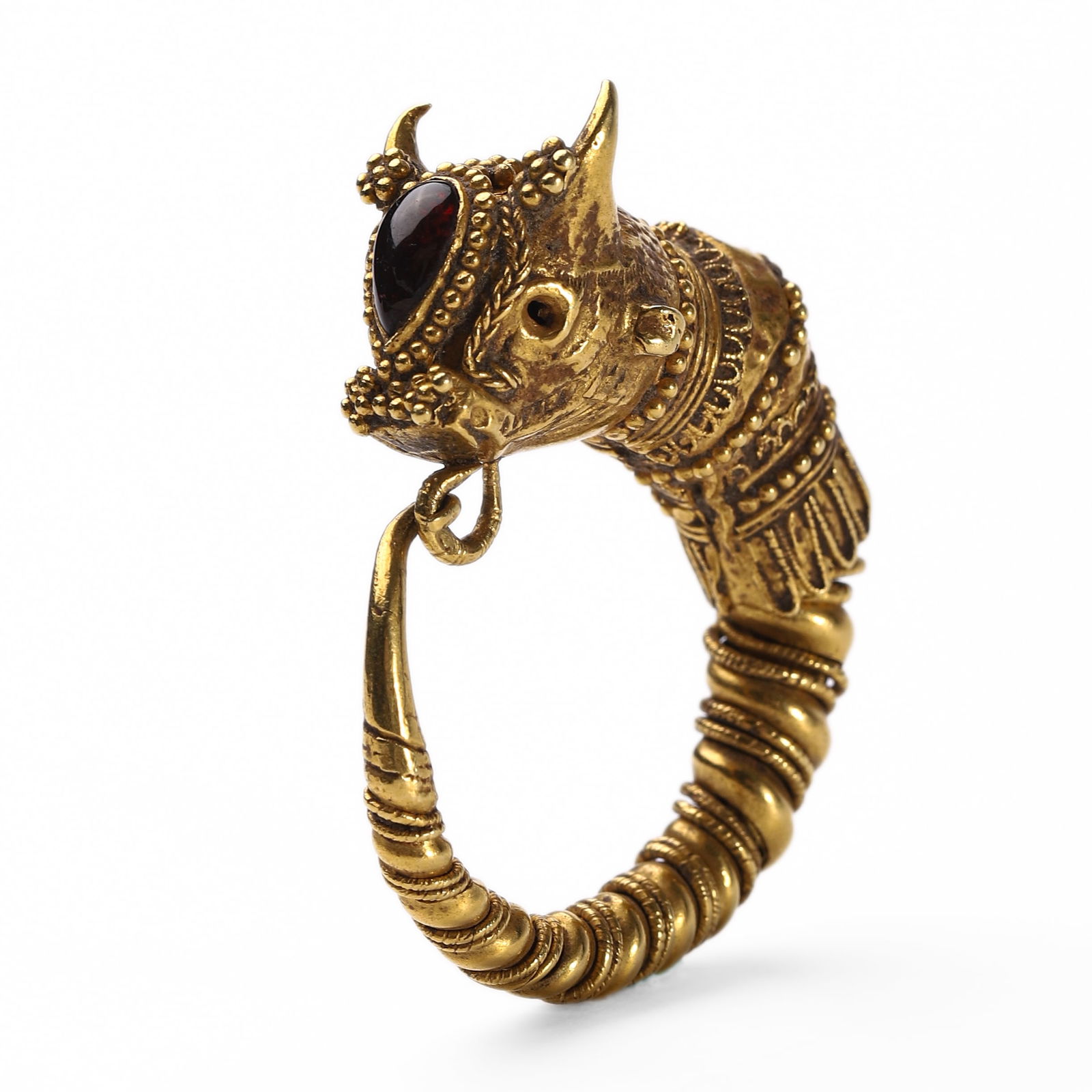 A GOLD EARRING IN THE FORM OF A BULL’S HEAD: Dimensions: Length: 1 3/4 in. (4.5 cm); Weight: 14.4 g This striking earring is crafted in high-karat gold in the form of a stylized bull’s head, adorned with fine granulation, twisted wire