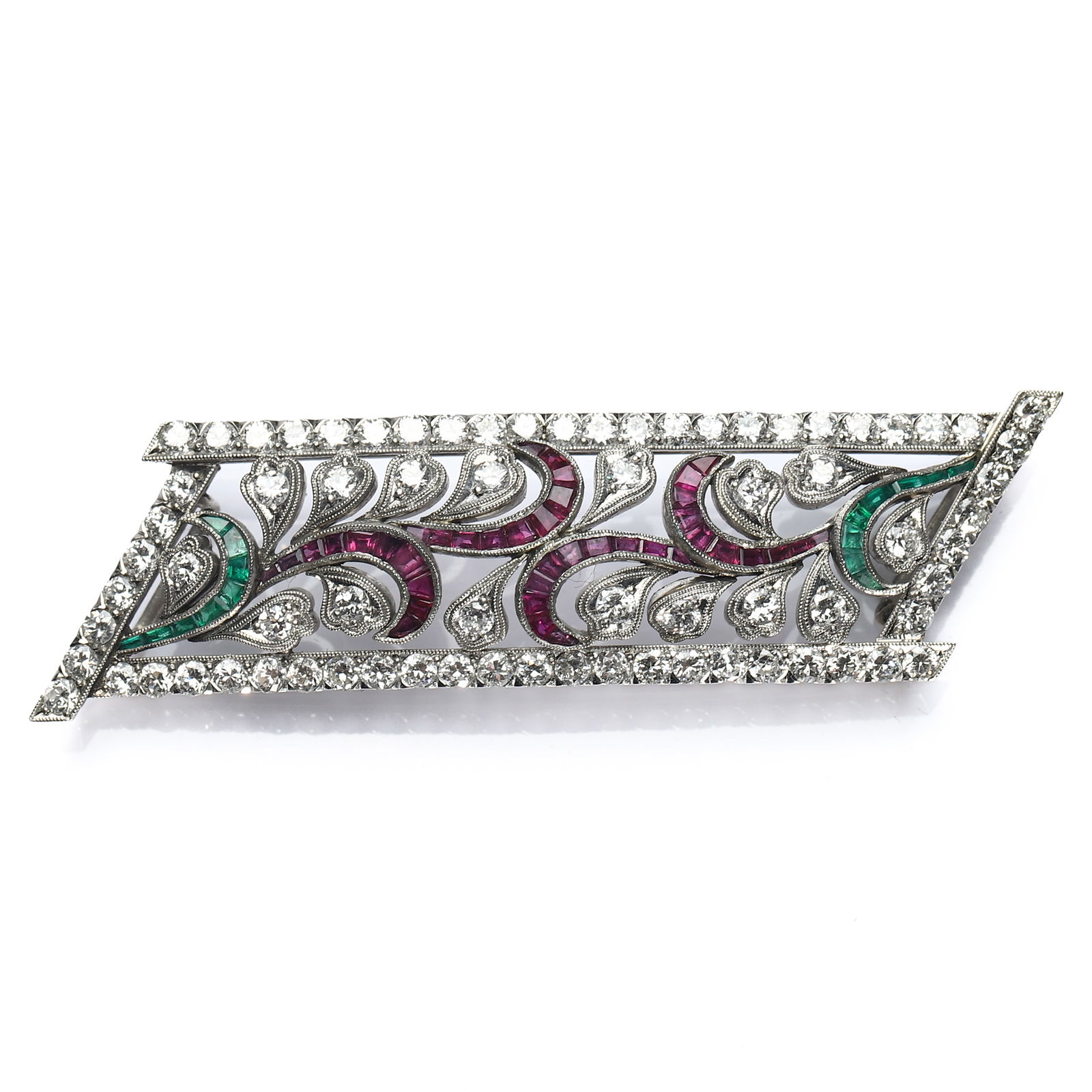 ART DECO PLATINUM, DIAMOND, RUBY AND EMERALD BROOCH: Dimensions 2 7/16 × 11/16 in. (6.2 × 1.7 cm)Weight: 14.9 g Description An elegant Art Deco brooch crafted in platinum, featuring an elongated rectangular form with openwork scrolling motifs. The