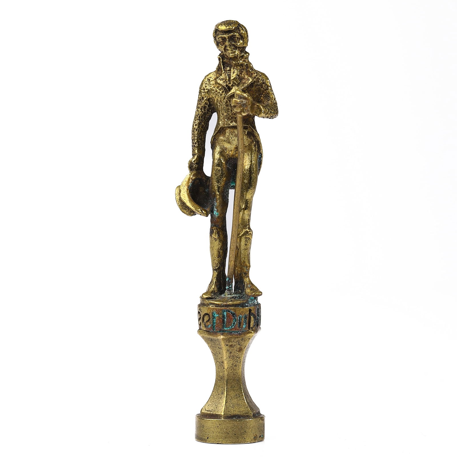 A GILT BRONZE GENTLEMAN FIGURAL SEAL: Dimensions Height 3 1/2 in (8.9 cm); Weight 48.1 g. Description A gilt bronze seal modeled as a finely dressed gentleman holding a cane and a hat, standing atop a rounded pedestal base with decorative