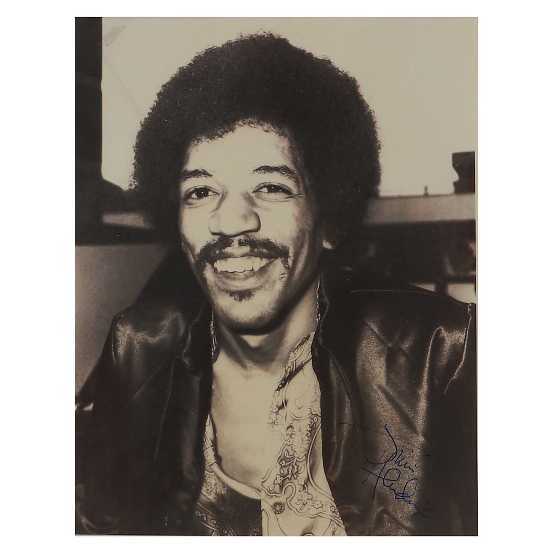 JIMI HENDRIX PORTRAIT PHOTOGRAPH: Title: JIMI HENDRIX PORTRAIT PHOTOGRAPH Material: Gelatin silver print, mounted on board Signature: Signed “Jimi Hendrix” in blue ink, lower right Dimensions Photograph 7 11/16 × 9 7/8 in.