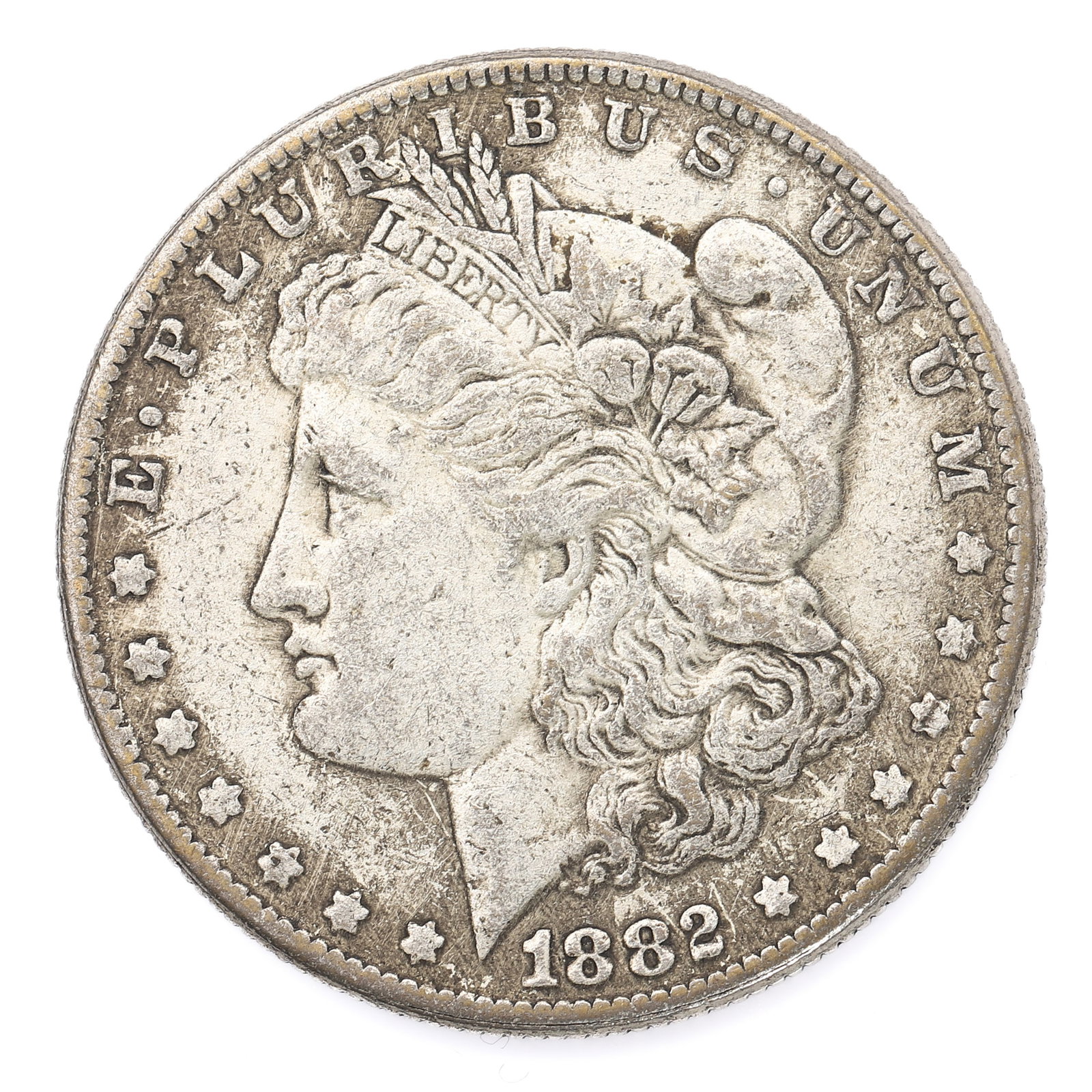 AN 1882 UNITED STATES MORGAN SILVER DOLLAR: Dimensions: Diameter: 1 1/2 in (3.77 cm); Weight: 24.5 g Description This 1882 Morgan silver dollar features the iconic left-facing portrait of Liberty by George T. Morgan, framed by thirteen stars